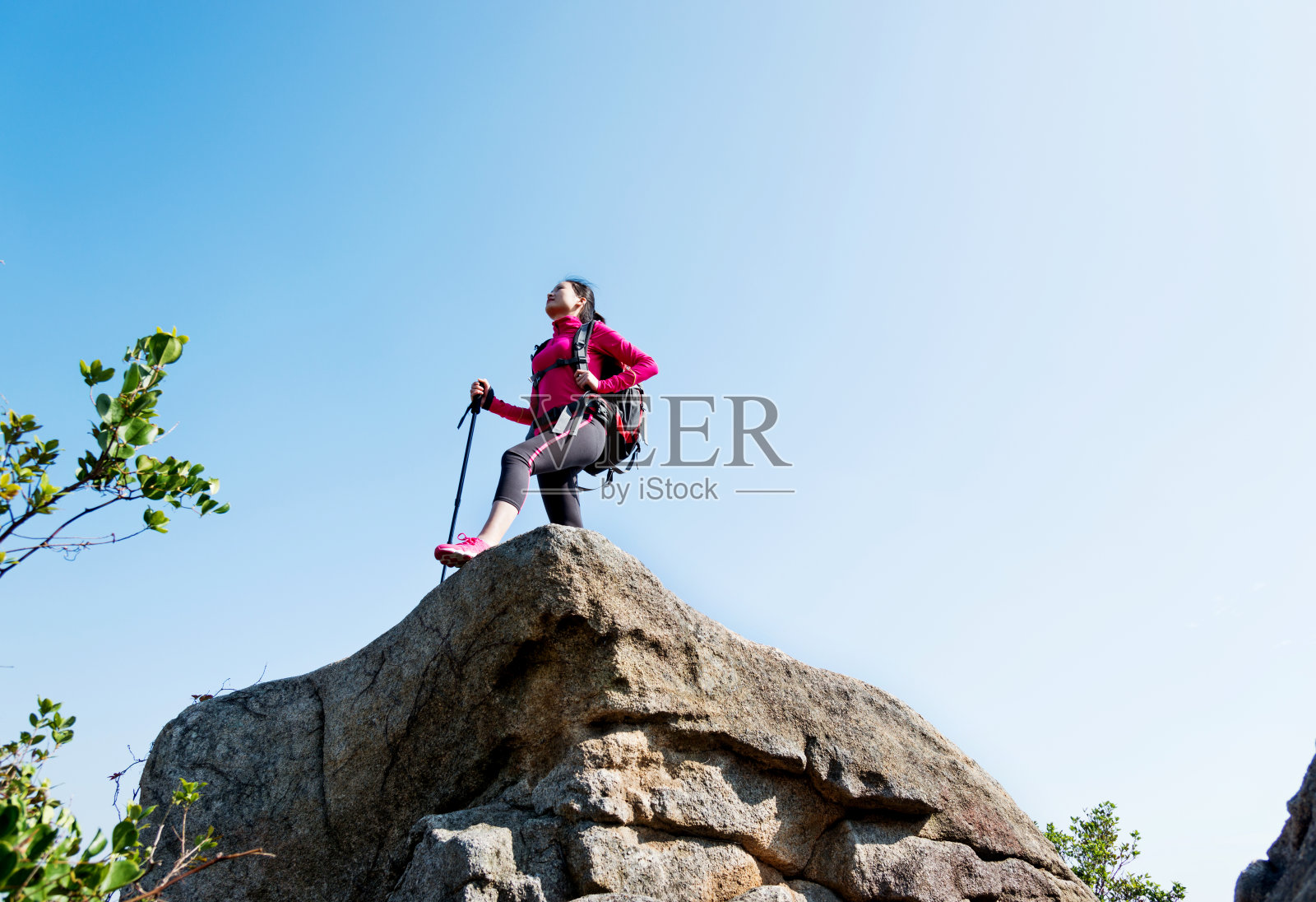 女背包客在山顶岩石的边缘照片摄影图片