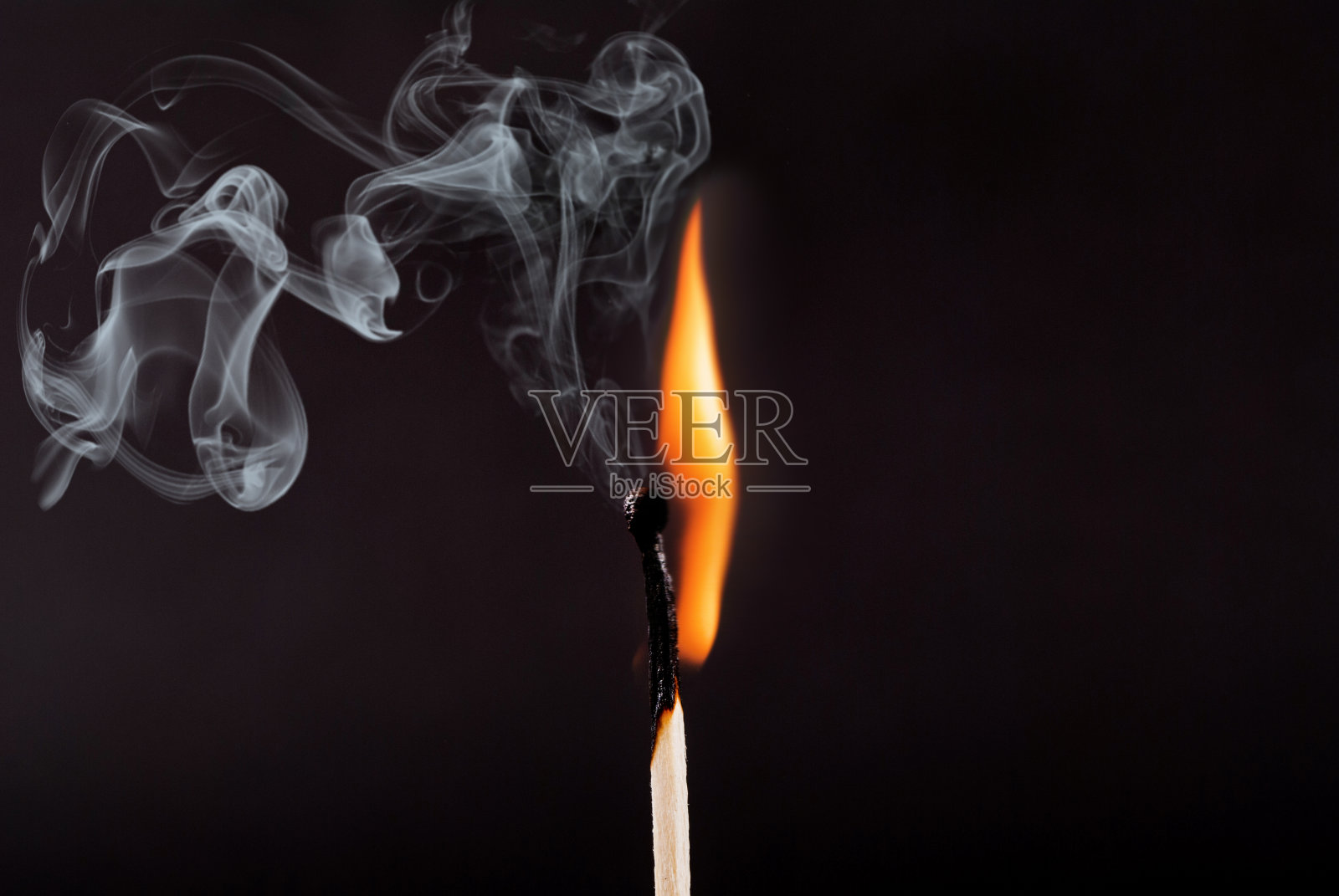 火柴粘着火焰和烟雾燃烧着，孤立在黑色的背景上照片摄影图片