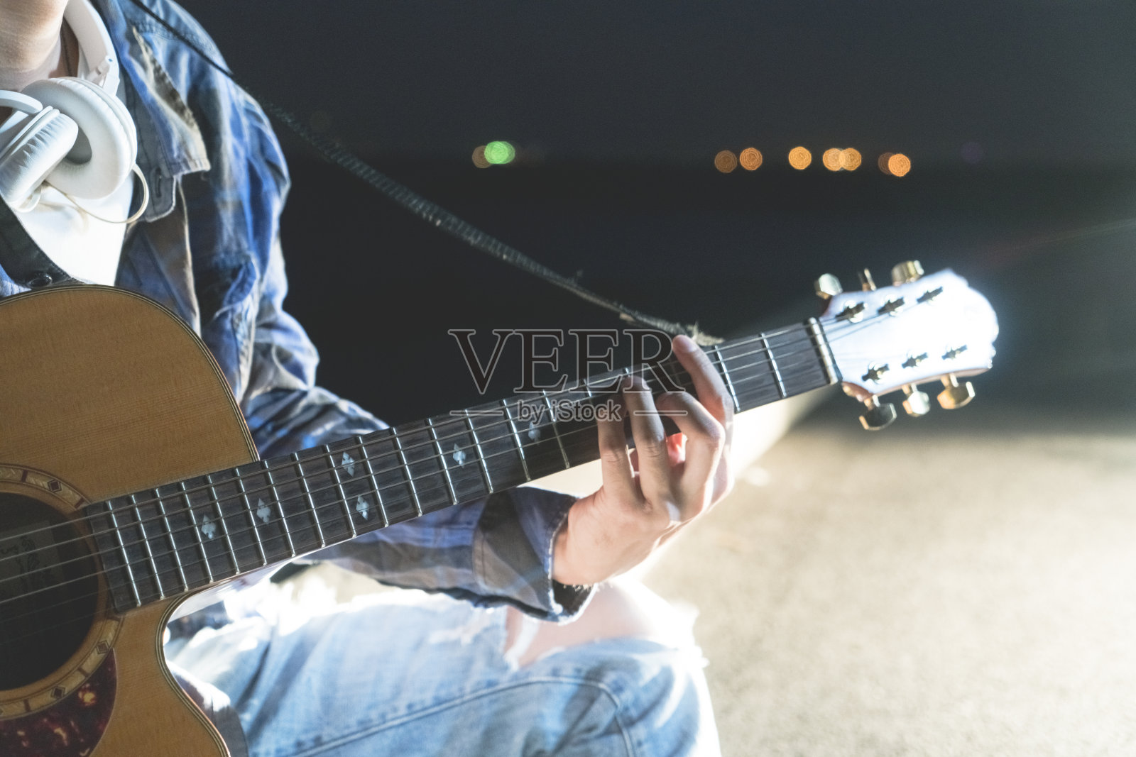 在城市海滨弹奏吉他的男子手的特写照片摄影图片