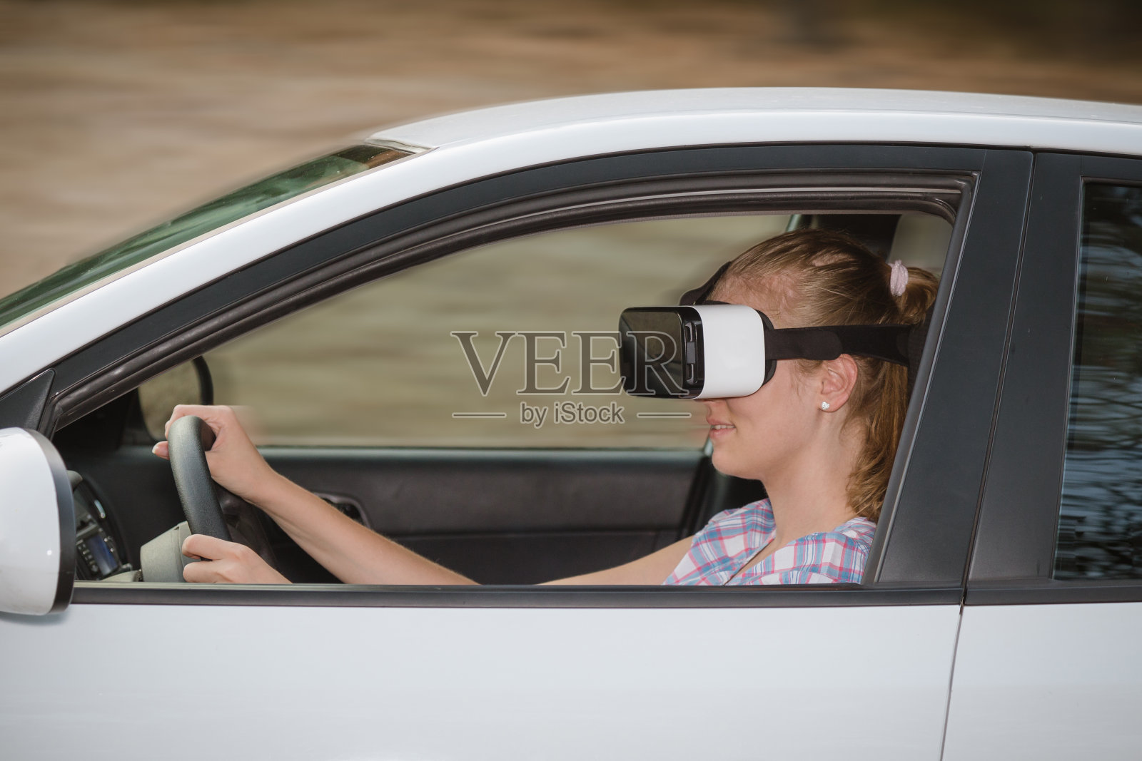 戴着虚拟现实眼镜学习开车的女人照片摄影图片