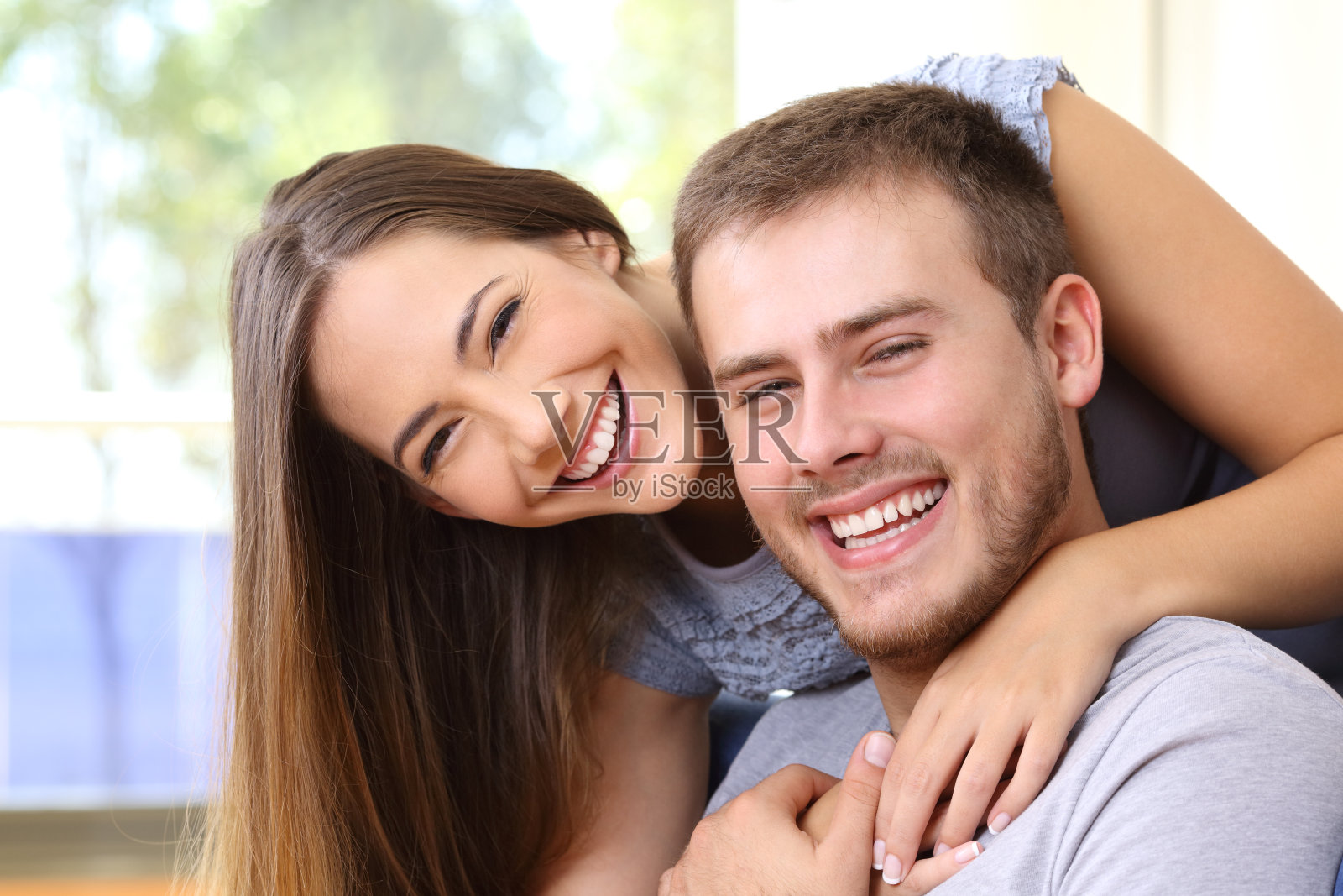 幸福的夫妇在家里笑着，牙齿很漂亮照片摄影图片