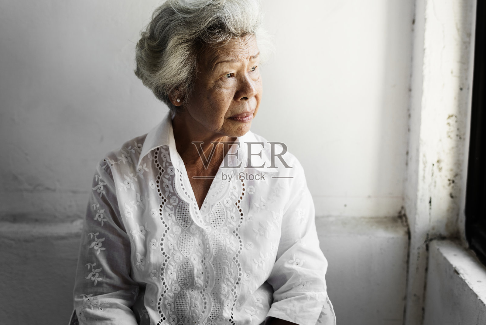 侧面的年长亚洲妇女与深思的脸表情照片摄影图片