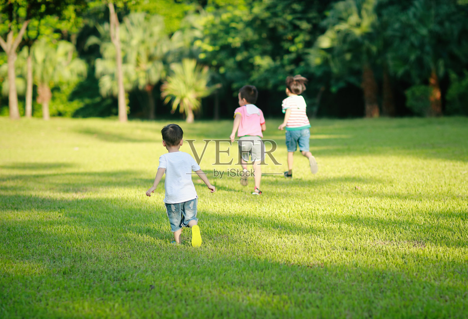 孩子们在草地上奔跑照片摄影图片