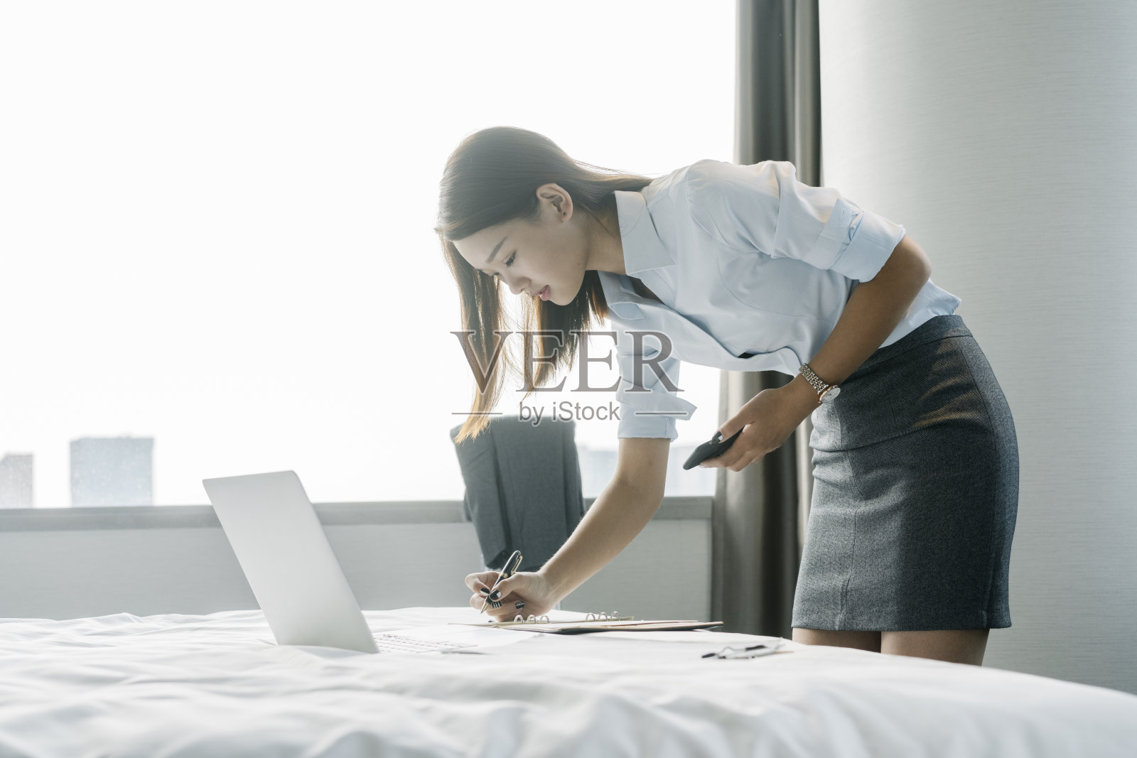 年轻的女商人在房间里用笔记本电脑工作照片摄影图片
