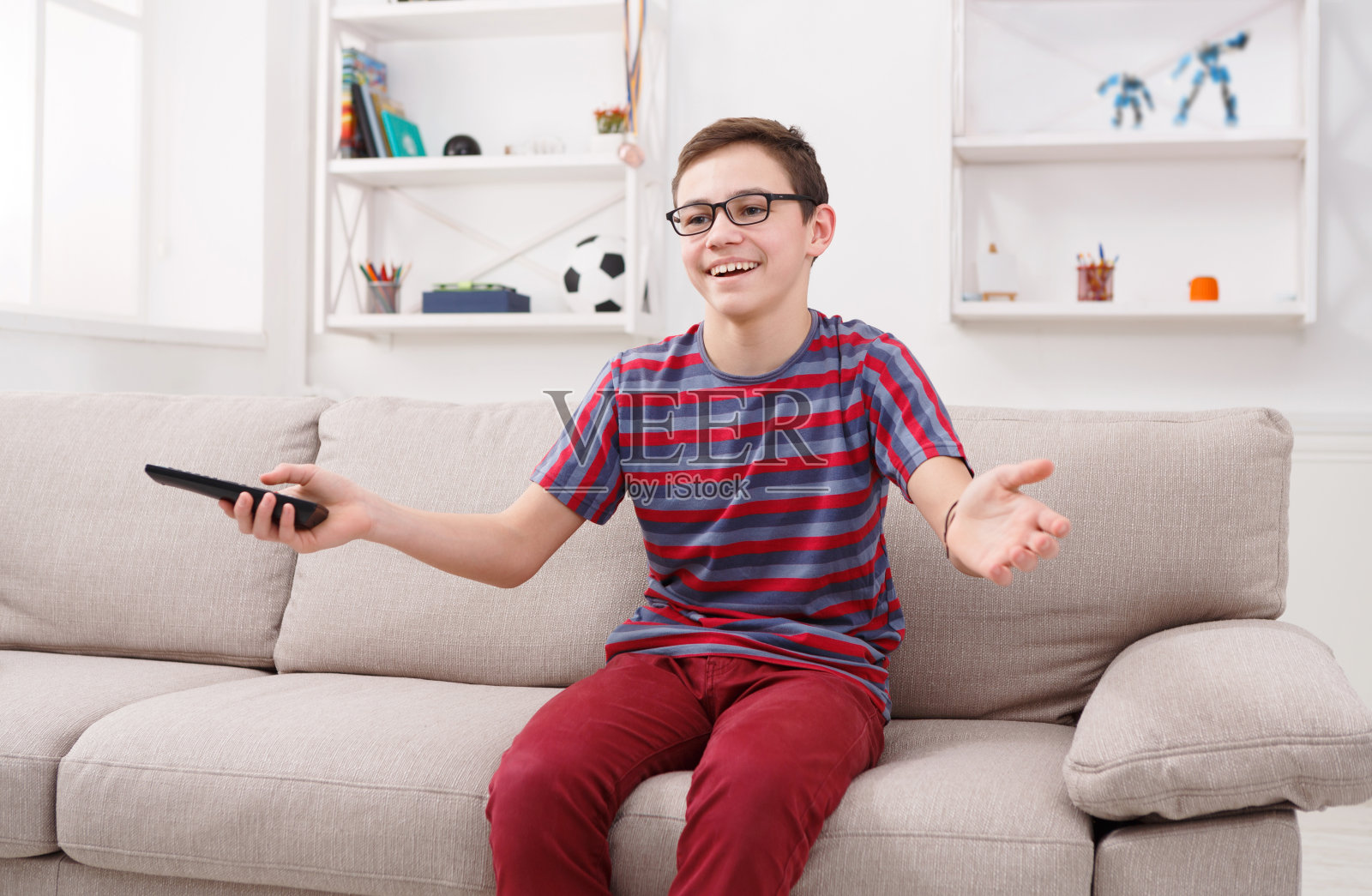 快乐的男孩在家里看有趣的电视节目照片摄影图片