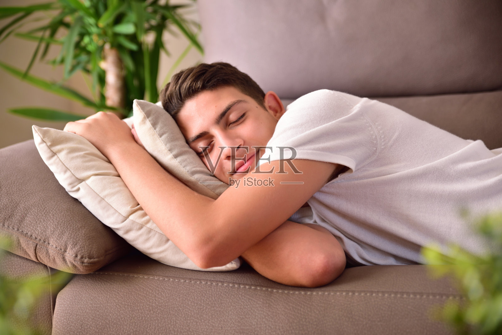 一个男人趴在家里的沙发垫子上打盹照片摄影图片