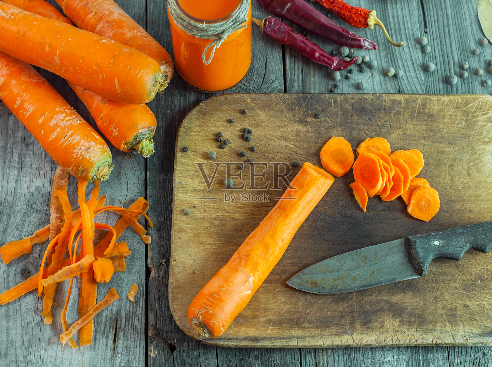 把新鲜的胡萝卜去皮，放在切好的菜板上照片摄影图片