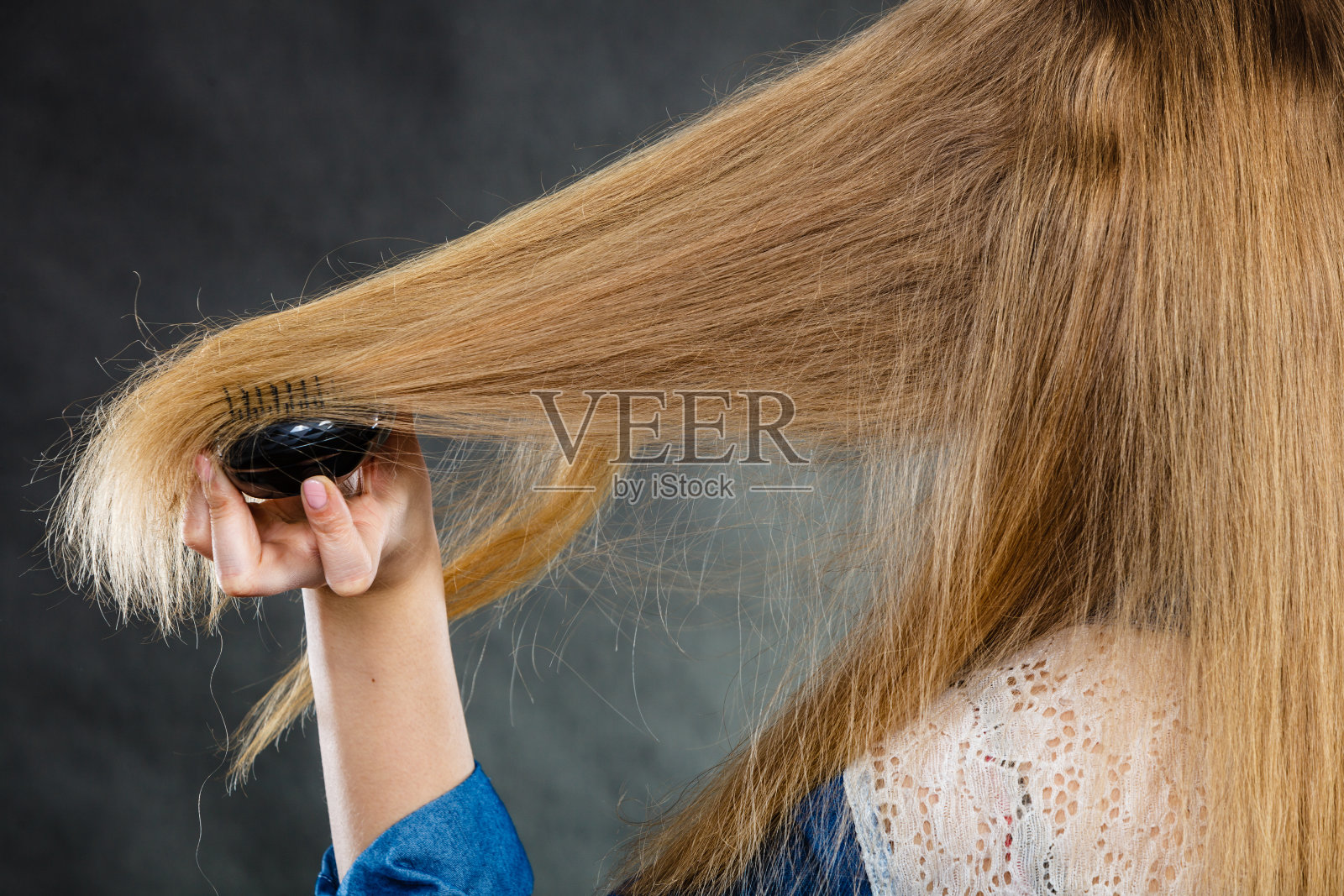 金发女人在梳头。照片摄影图片