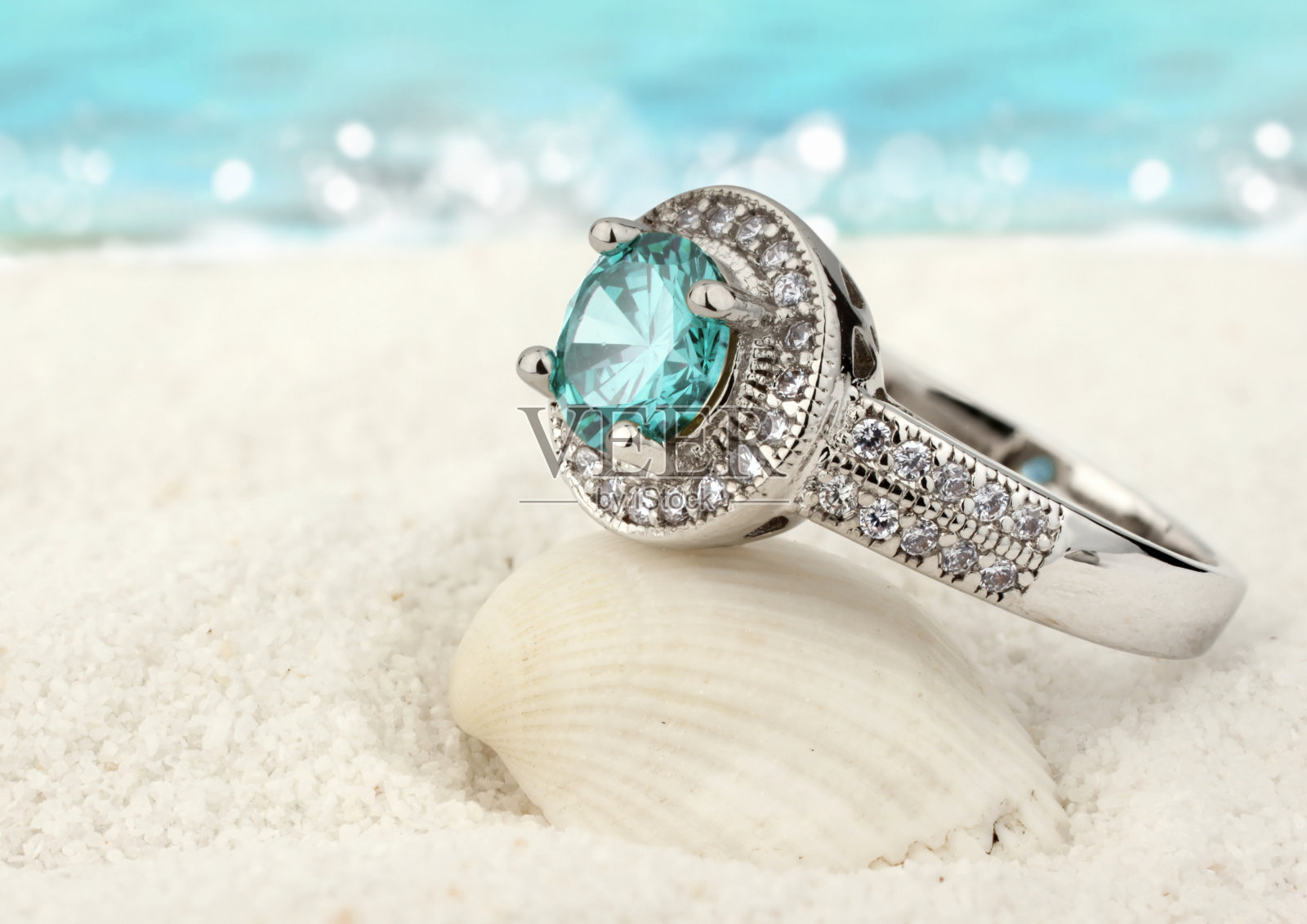 珠宝戒指与海蓝宝石宝石在沙滩上的背景照片摄影图片