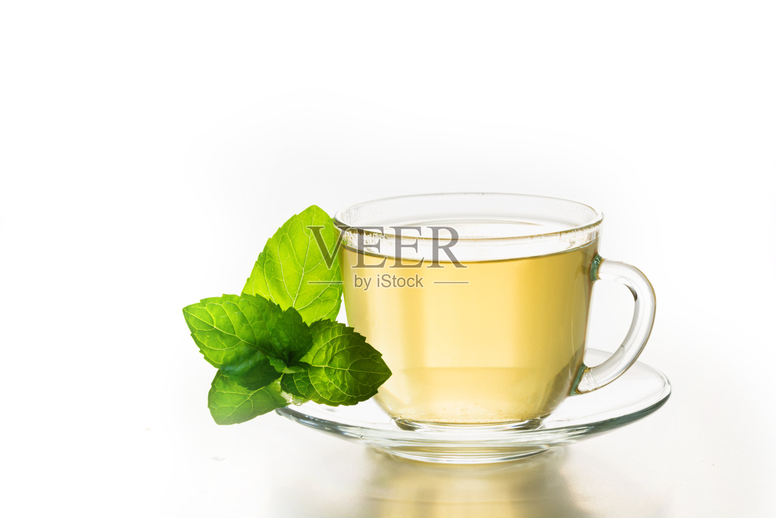 一杯绿茶和薄荷叶就白了。照片摄影图片