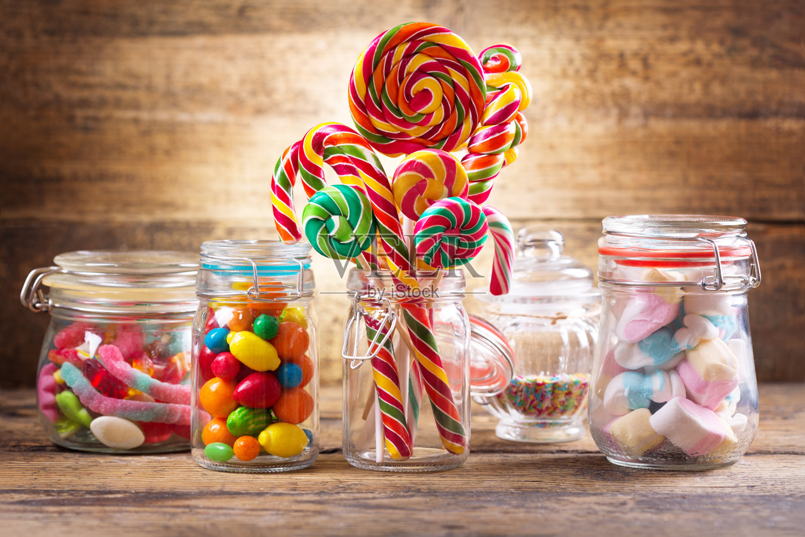 彩色的糖果，果冻，棒棒糖，棉花糖和果酱在一个玻璃瓶照片摄影图片