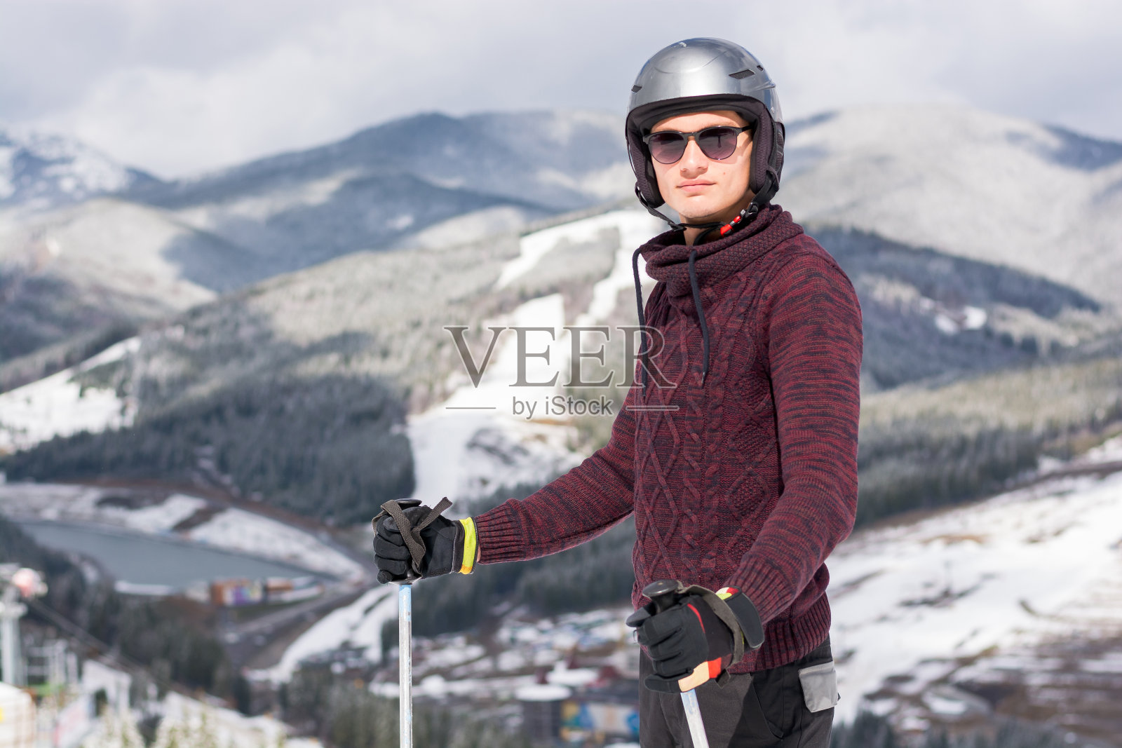 在山上戴着头盔的滑雪者照片摄影图片