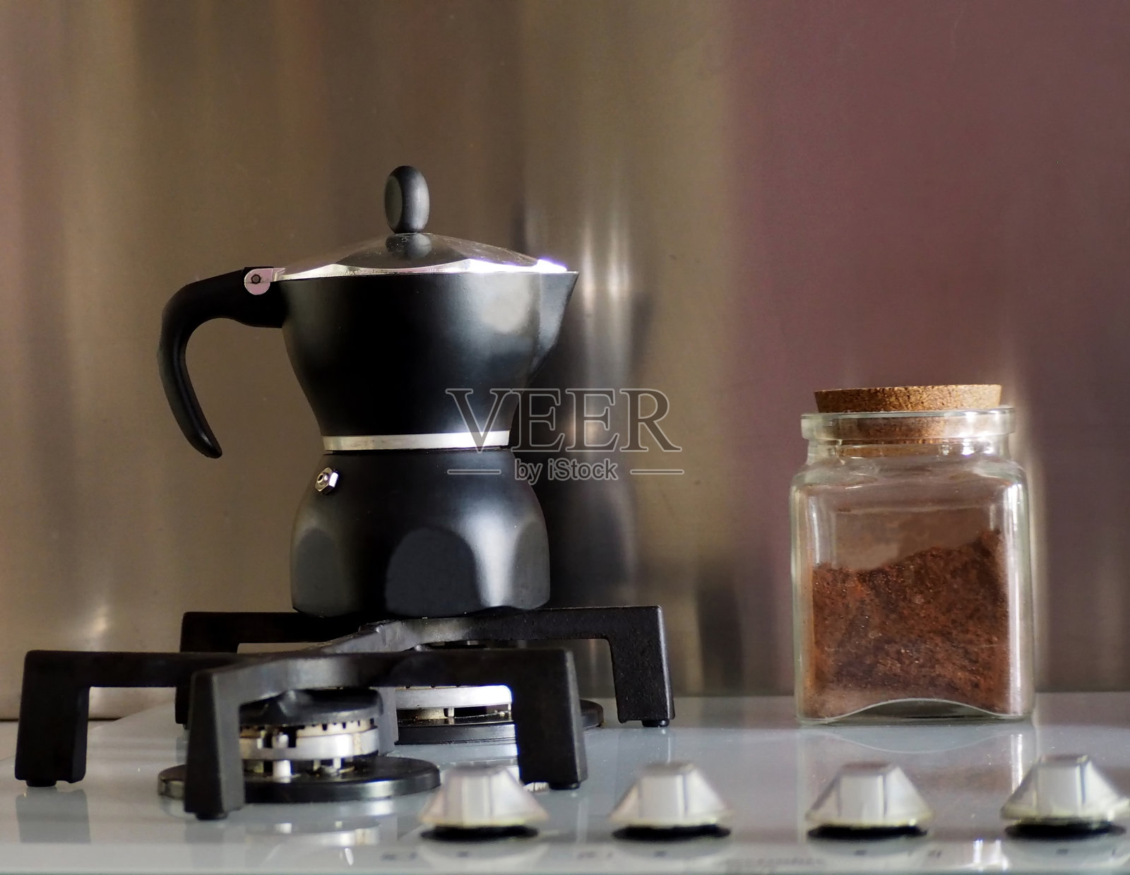 传统的意大利咖啡机，在炉子上放一个装满咖啡的玻璃罐照片摄影图片