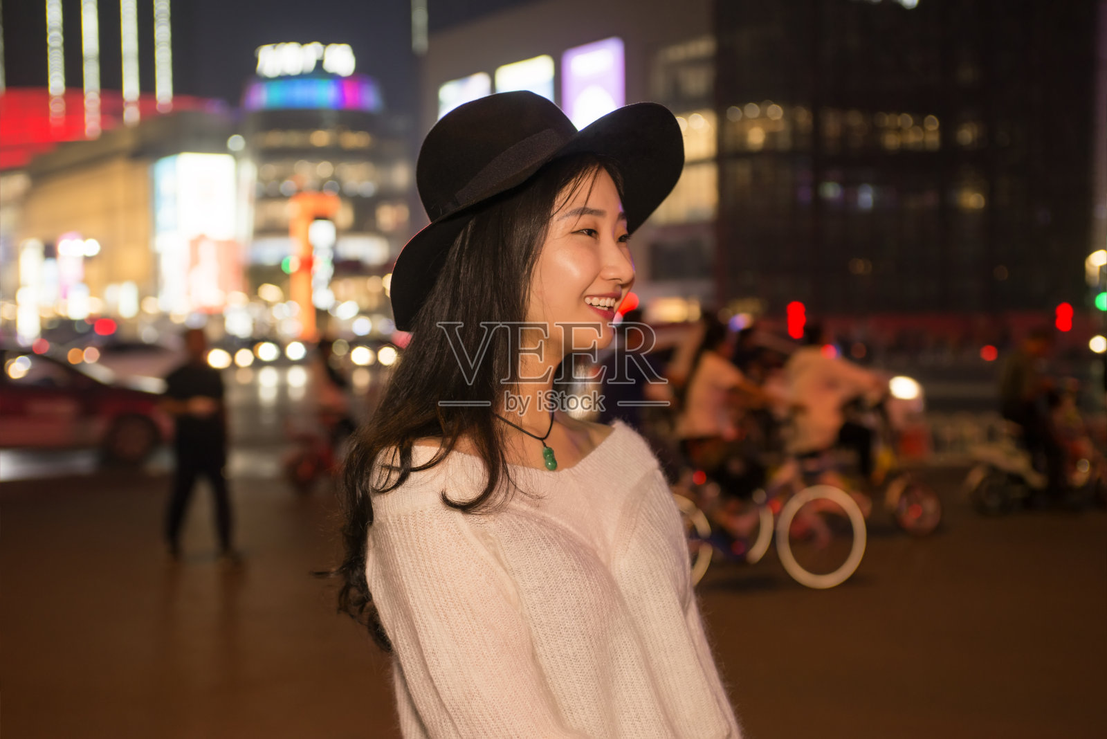 一个年轻美丽的女人在夜晚的城市街道上的肖像照片摄影图片