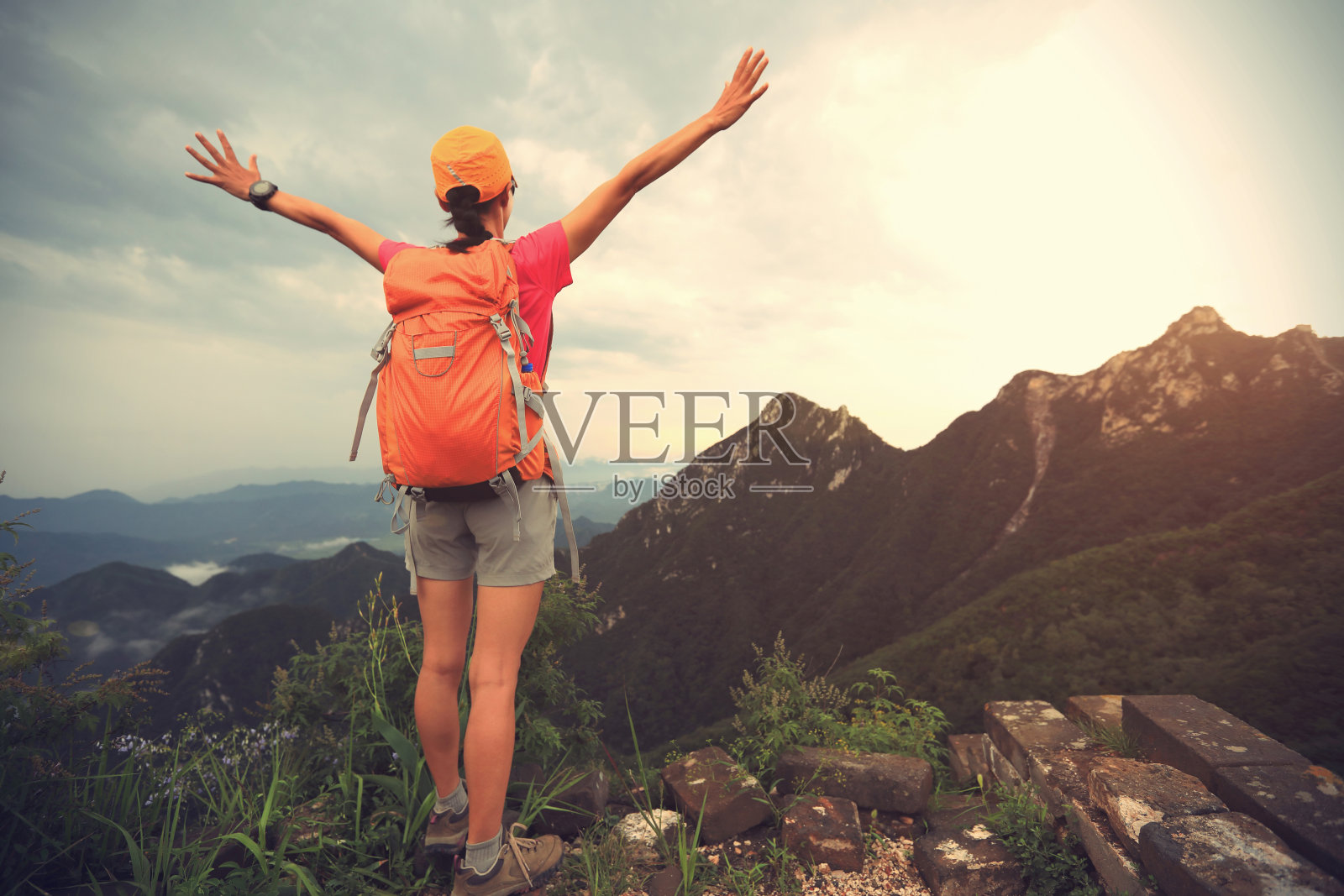 成功的女性徒步旅行者在山顶张开双臂照片摄影图片