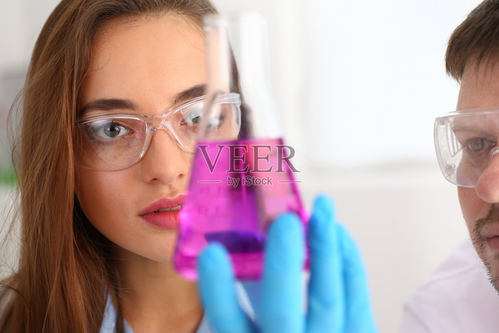 一个女化学家手里拿着一个试管，流出一种液体照片摄影图片