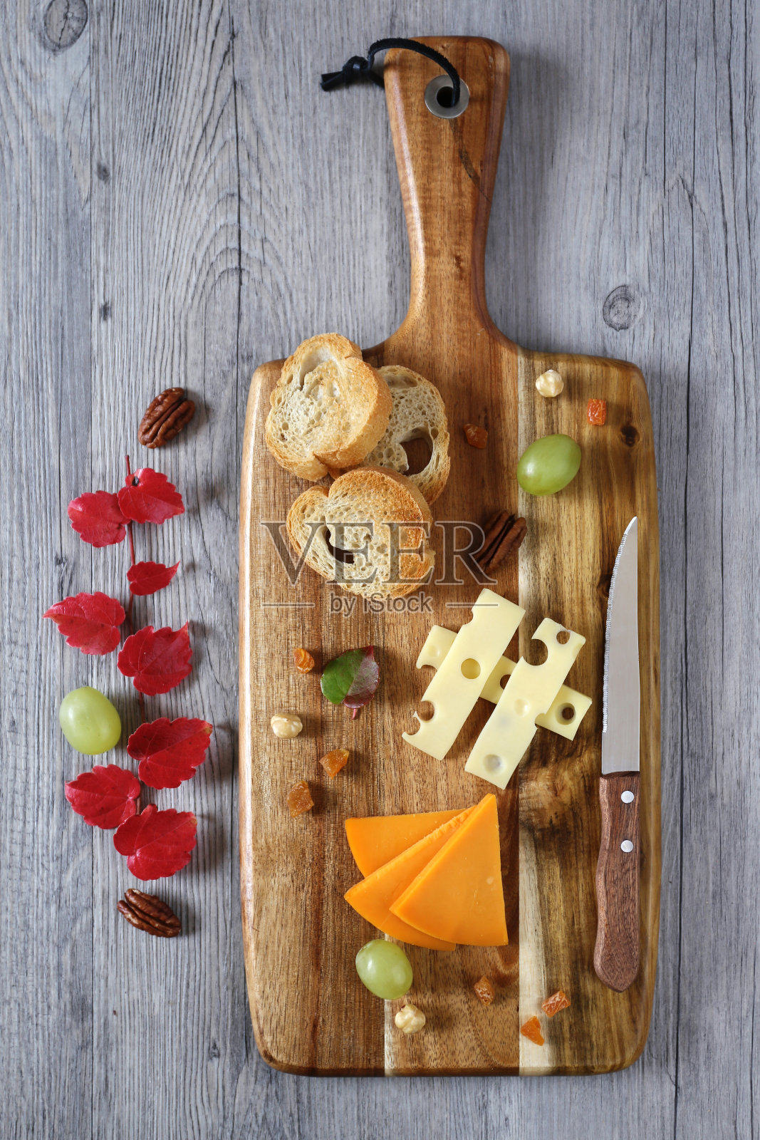 豪达奶酪，绿色的葡萄和红色的秋叶照片摄影图片