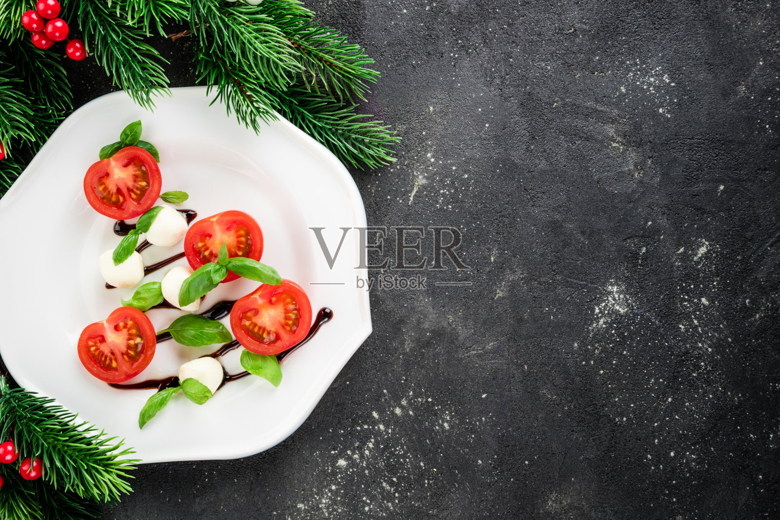 圣诞树形状的卡普里沙拉。暗色餐桌上的节日开胃菜。圣诞餐桌设置概念沙拉卡普勒。圣诞节的背景。俯视图照片摄影图片
