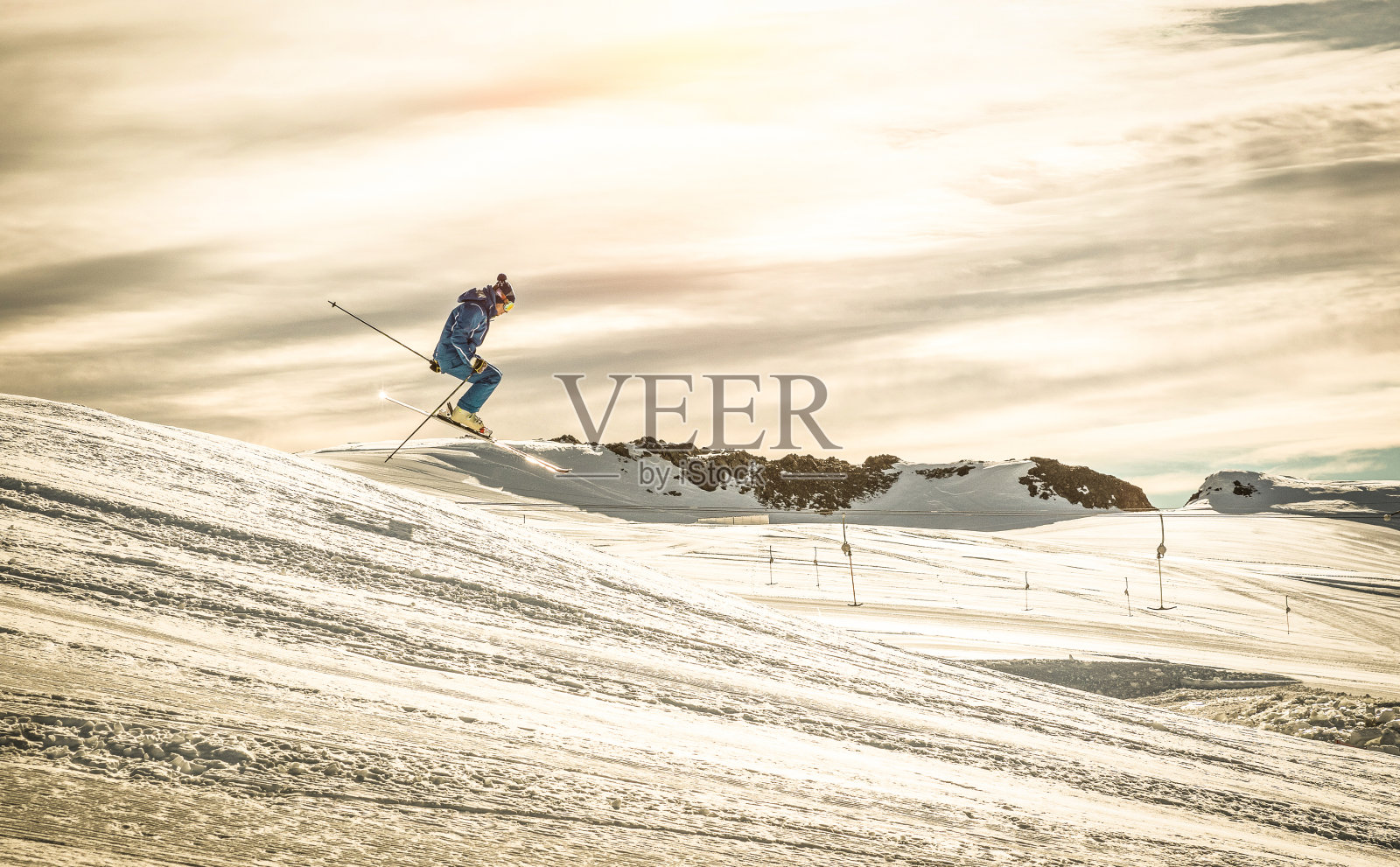专业滑雪者表演杂技跳跃在下坡展览-极限冬季运动概念与滑雪运动员在国际比赛-戏剧性的对比过滤器与阳光光晕照片摄影图片