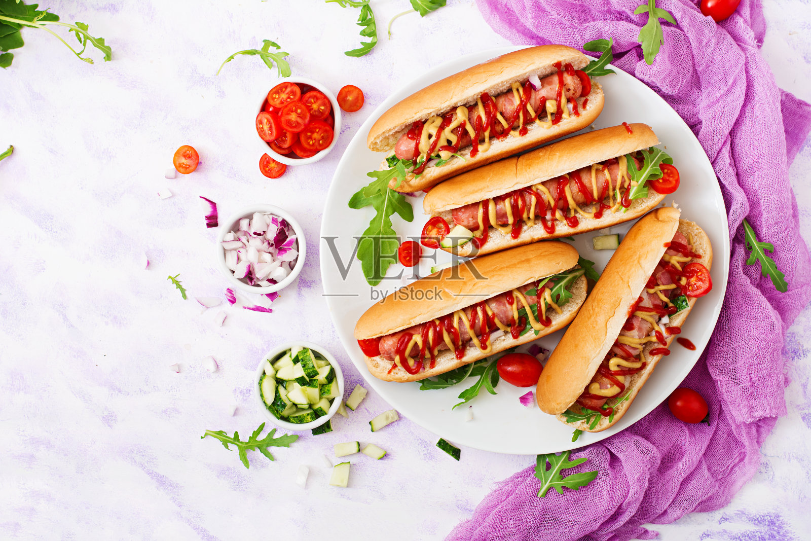 香肠热狗。白盘子里放培根、黄瓜、番茄和红洋葱。前视图。平的。照片摄影图片