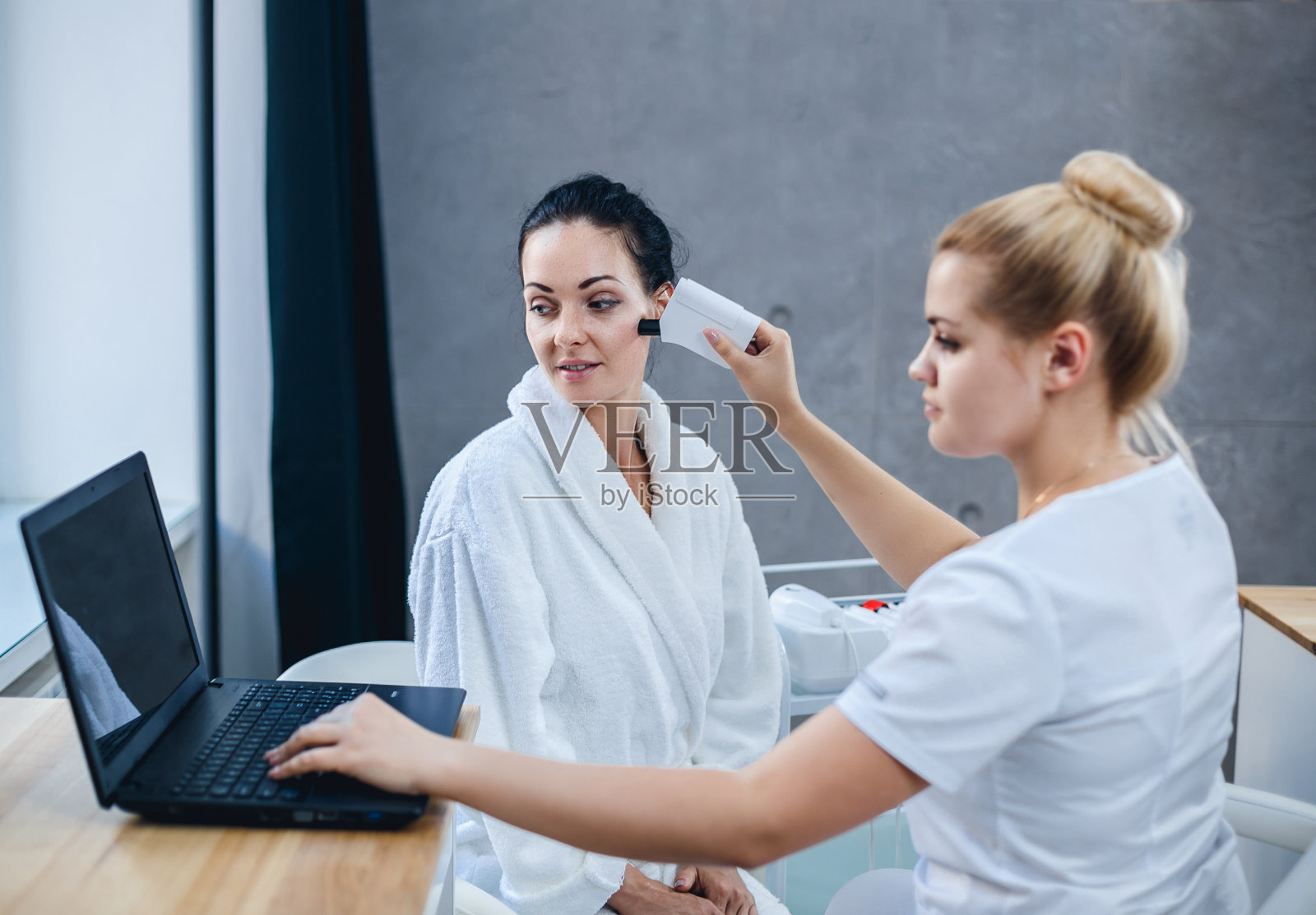 女医生和病人在面部皮肤检查。照片摄影图片