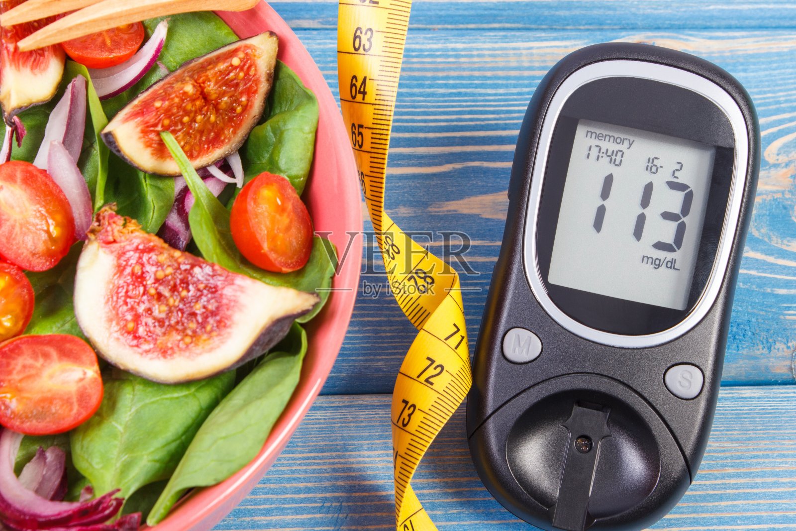 水果蔬菜沙拉和血糖仪用卷尺测量，糖尿病概念，减肥和健康营养照片摄影图片