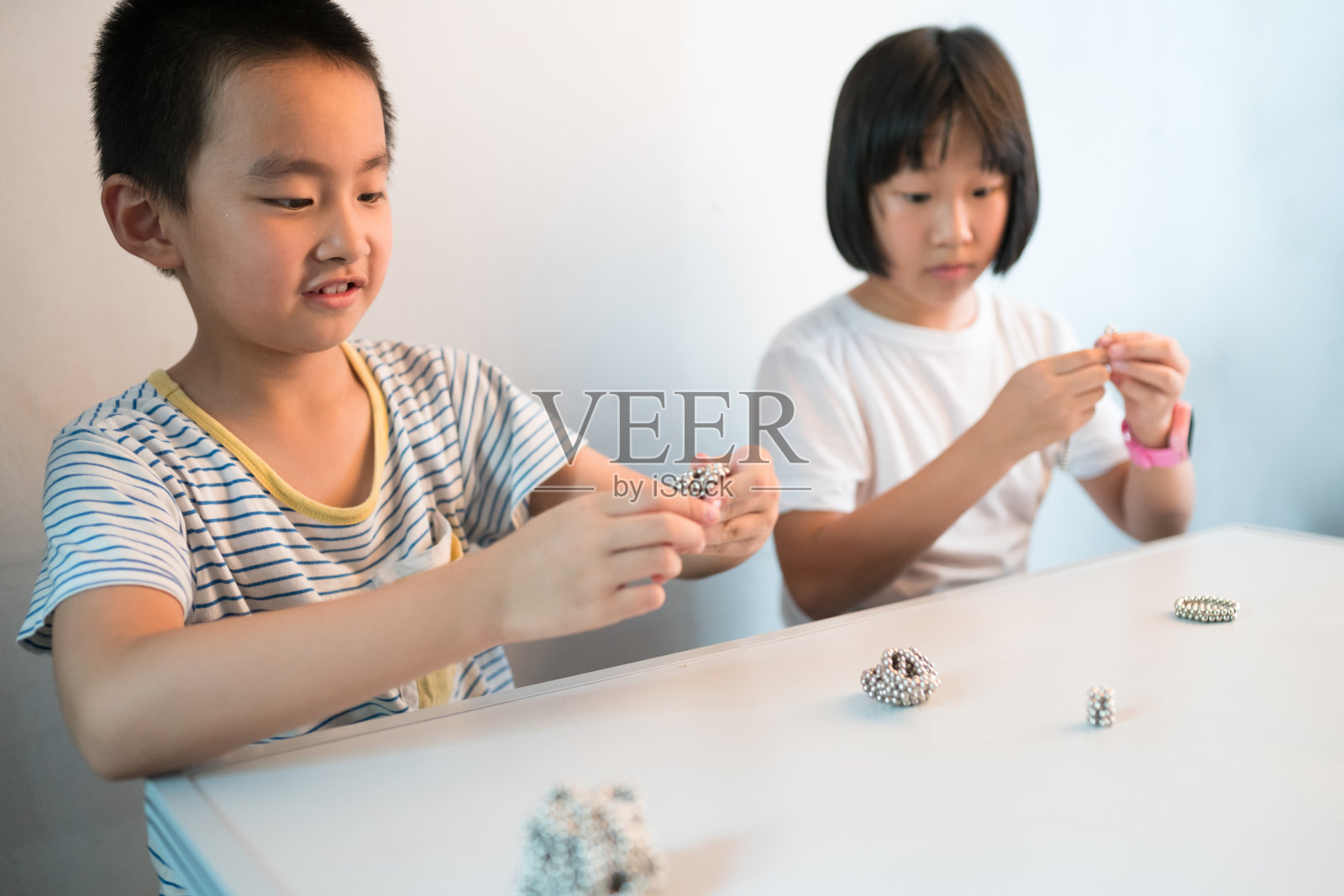 亚洲男孩和女孩一起玩磁珠照片摄影图片