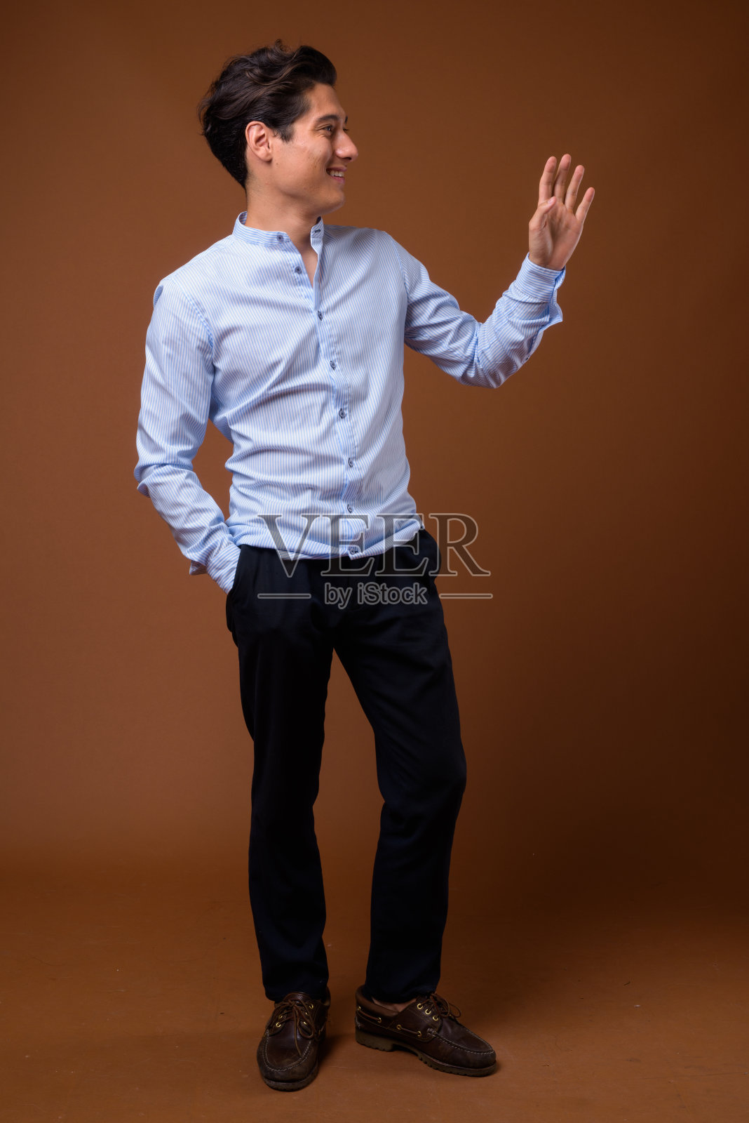 工作室拍摄的年轻多民族英俊的商人穿着蓝色衬衫，以彩色背景照片摄影图片
