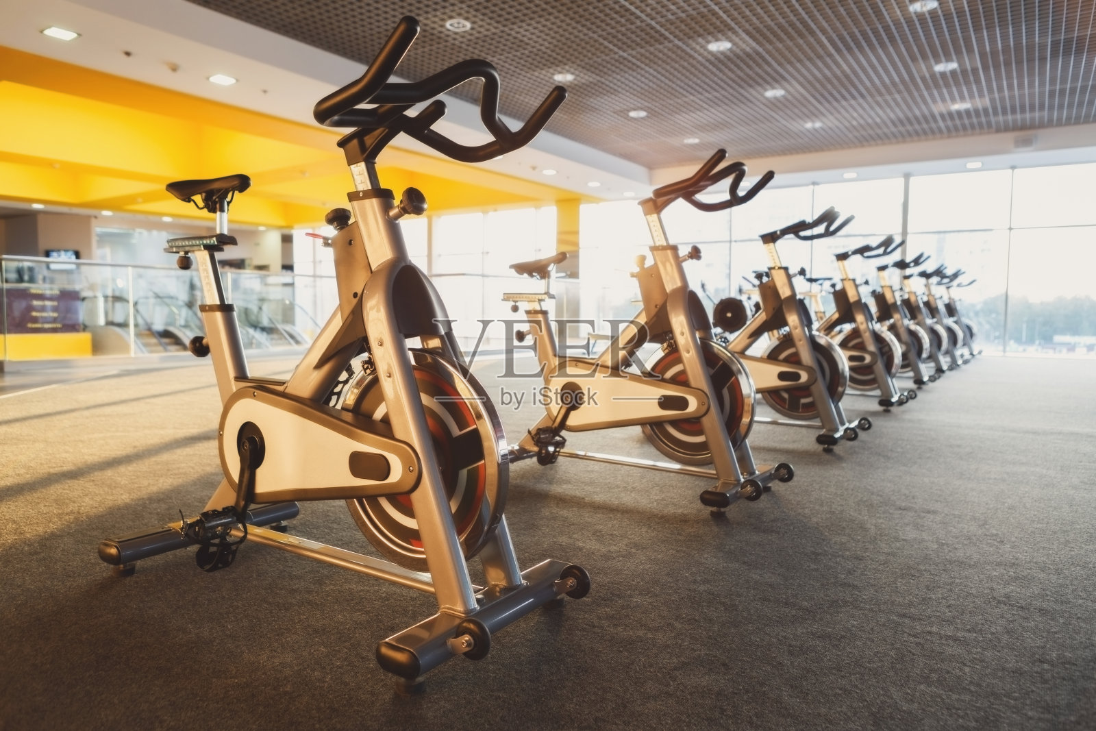 现代化的健身房内部配备健身器材，健身自行车照片摄影图片