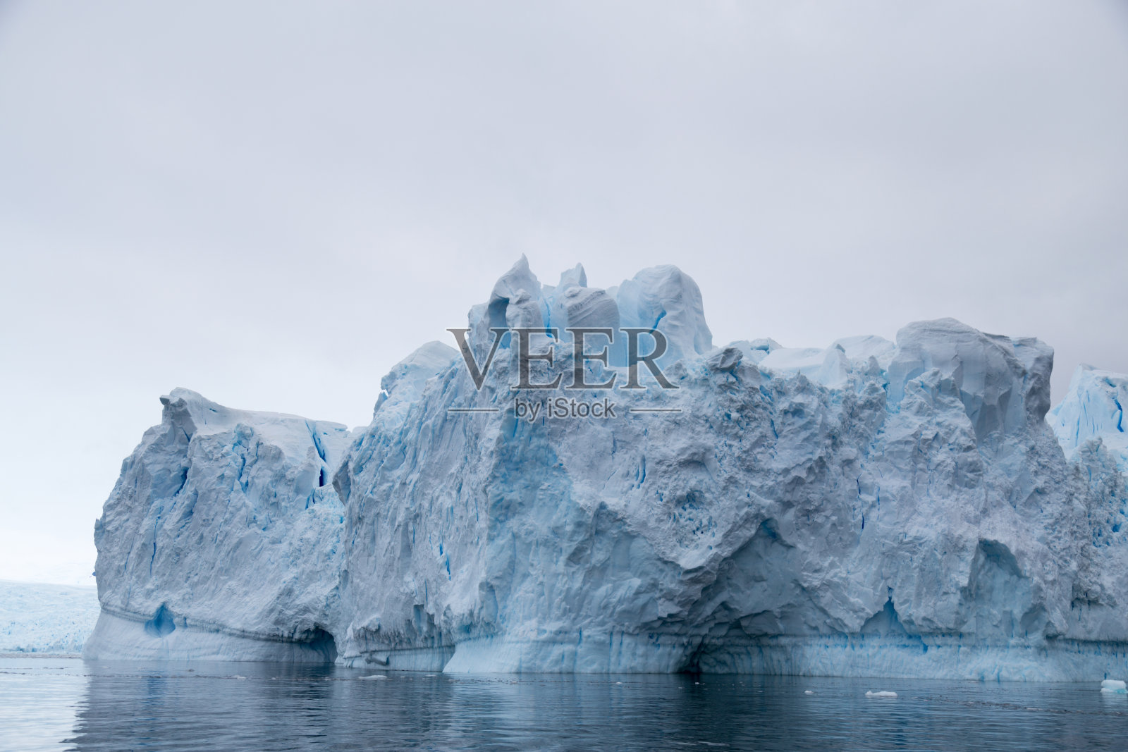 一座巨大的冰山从冰川崩解下来。展示了美丽的蓝色冰照片摄影图片