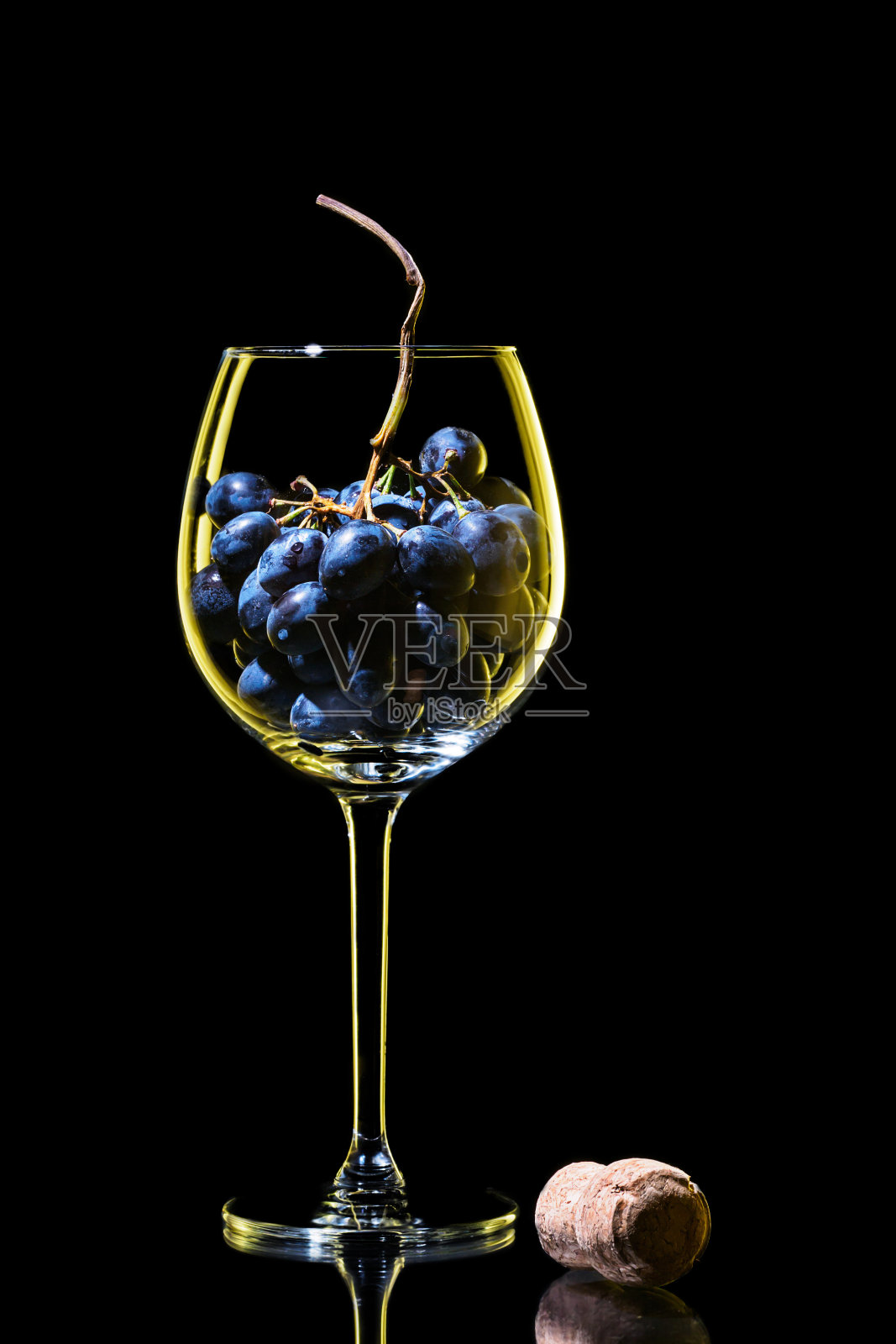 优雅的轮廓葡萄酒杯与一簇红葡萄和传统软木塞照片摄影图片