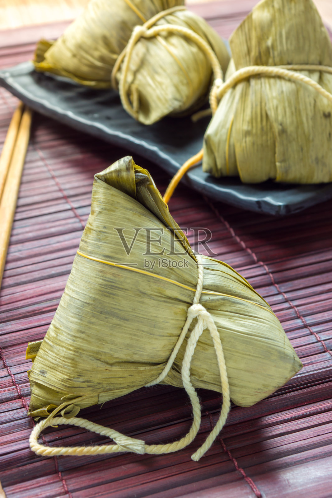 端午节吃粽子或中国传统的糯米团子照片摄影图片