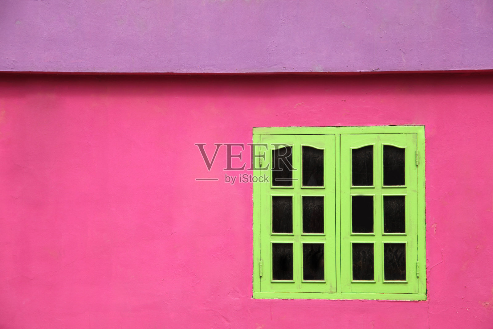 一个色彩鲜艳的建筑物的特写，粉红色的墙壁，石灰绿色的窗户和紫色的屋顶，加勒比。照片摄影图片
