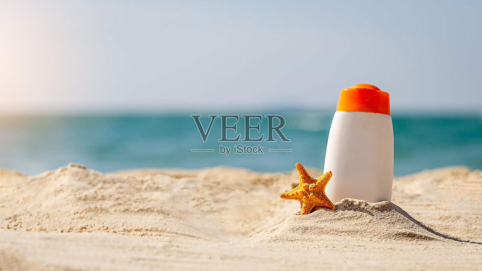瓶防晒油和海星在热带海滩，海滩配件和夏季概念，拷贝空间照片摄影图片