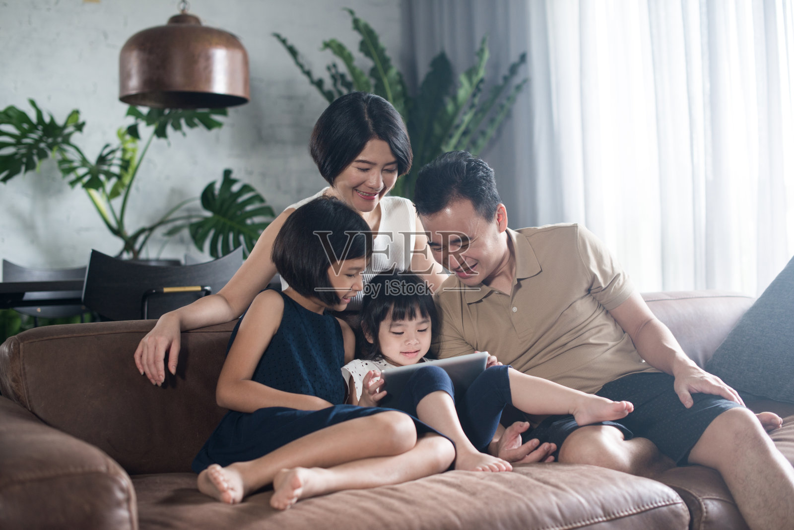 亚洲家庭一起呆在家里。照片摄影图片