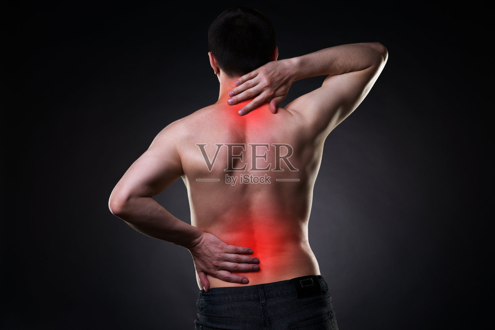 背部疼痛，背部疼痛的男人在黑色背景上照片摄影图片