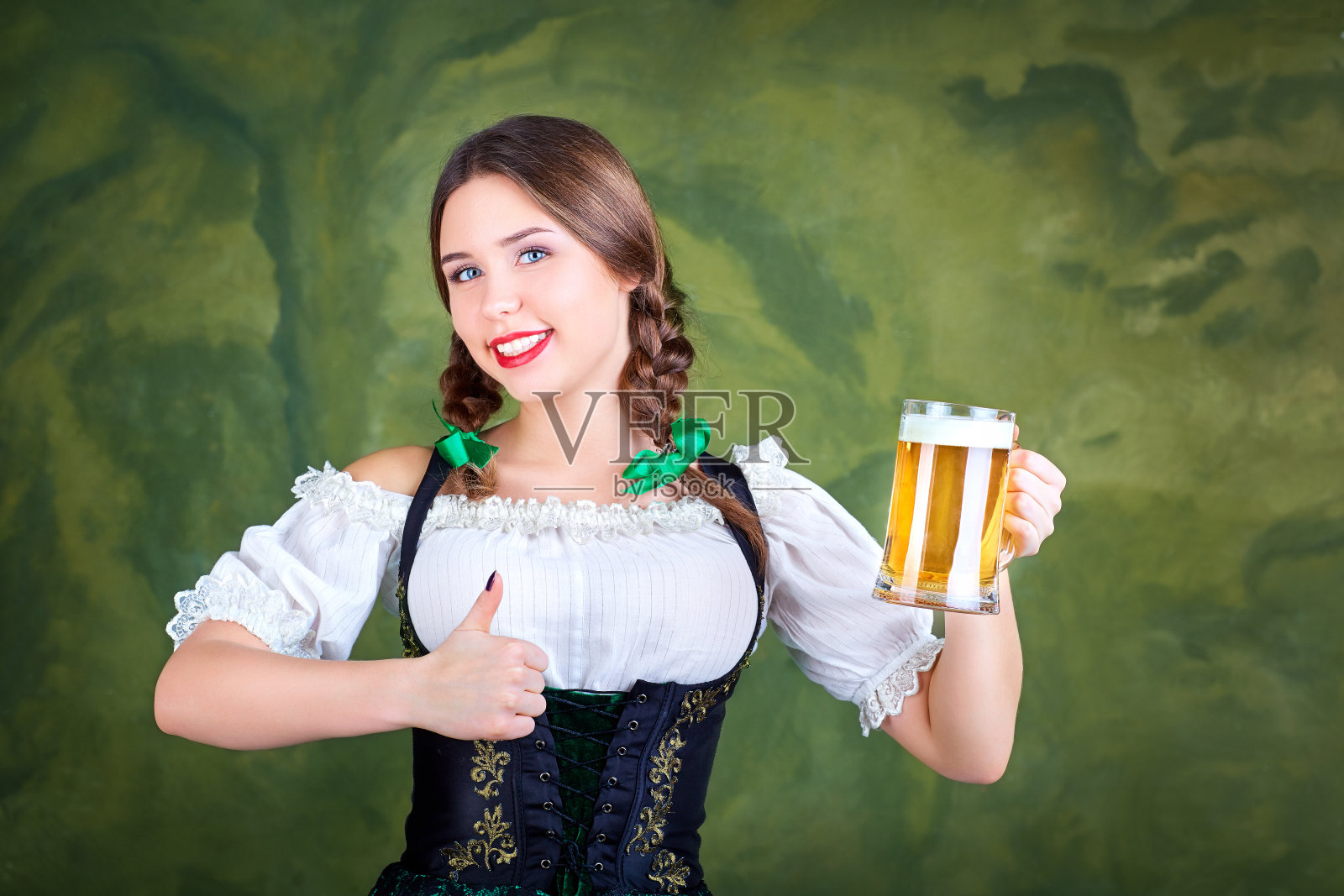 年轻女孩服务员啤酒节在民族服装与马克杯照片摄影图片