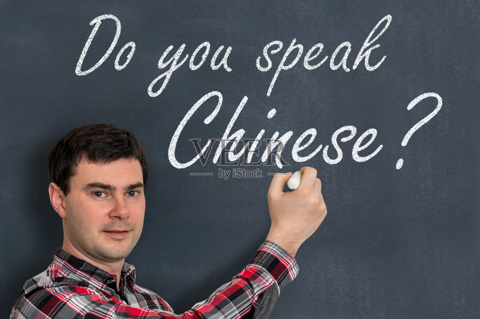 你会说中文吗?用粉笔在黑板上写字的人照片摄影图片