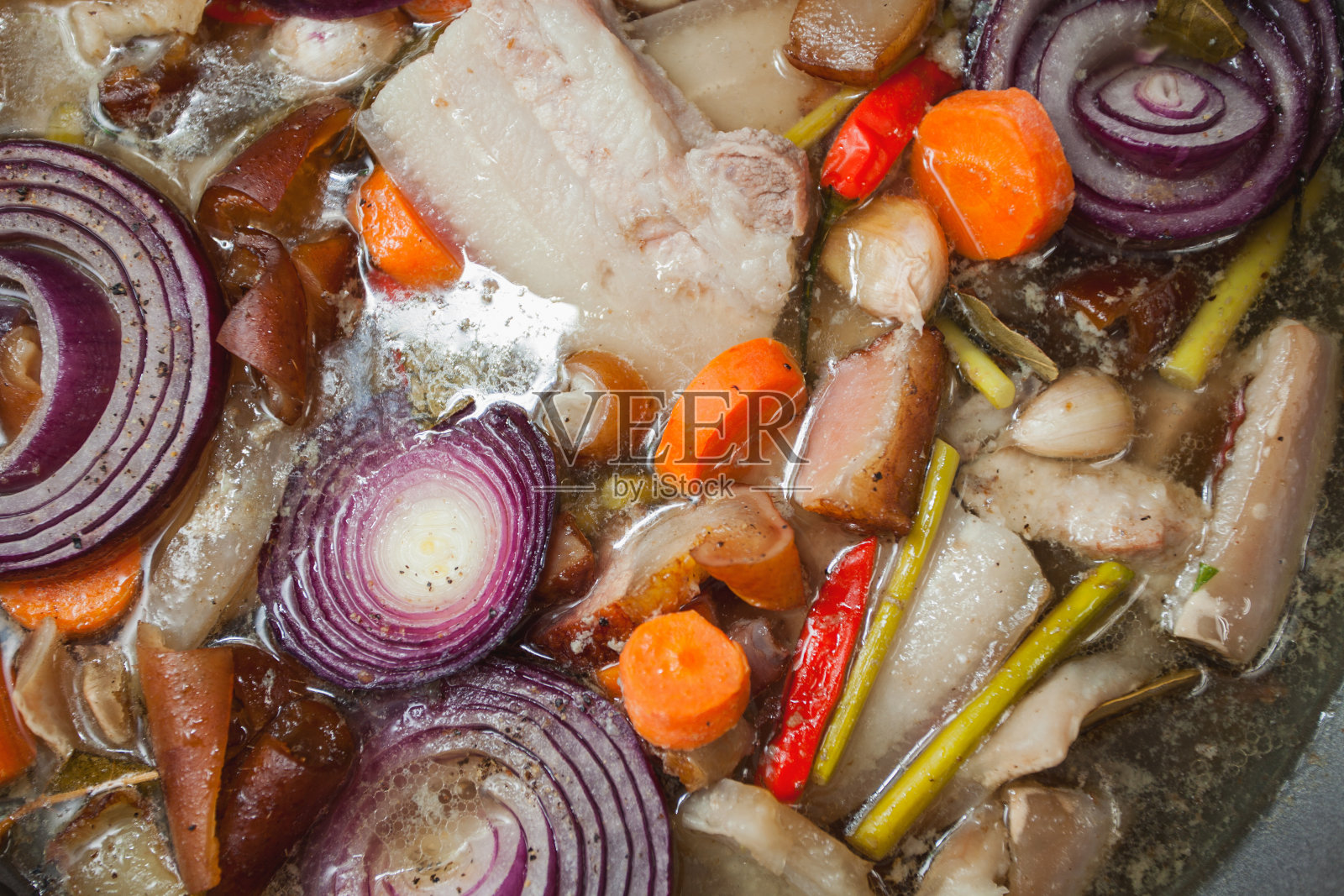 烟熏猪肉和蔬菜一起慢慢煮熟;照片摄影图片