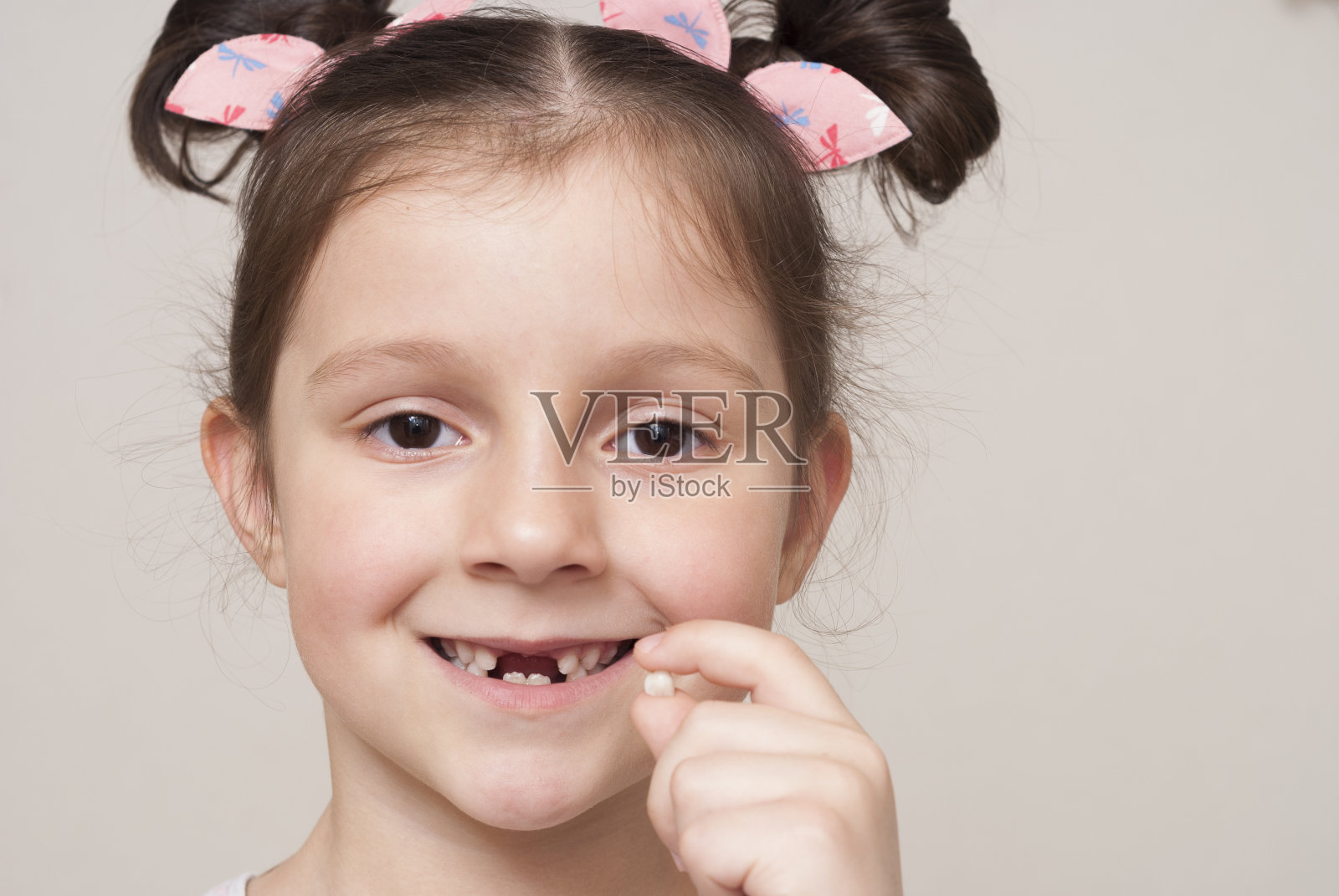 小女孩拿着一颗乳牙照片摄影图片