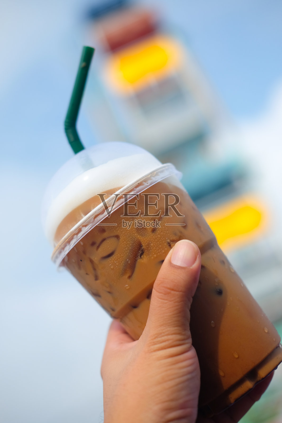 冰咖啡在塑料玻璃与游乐园背景照片摄影图片