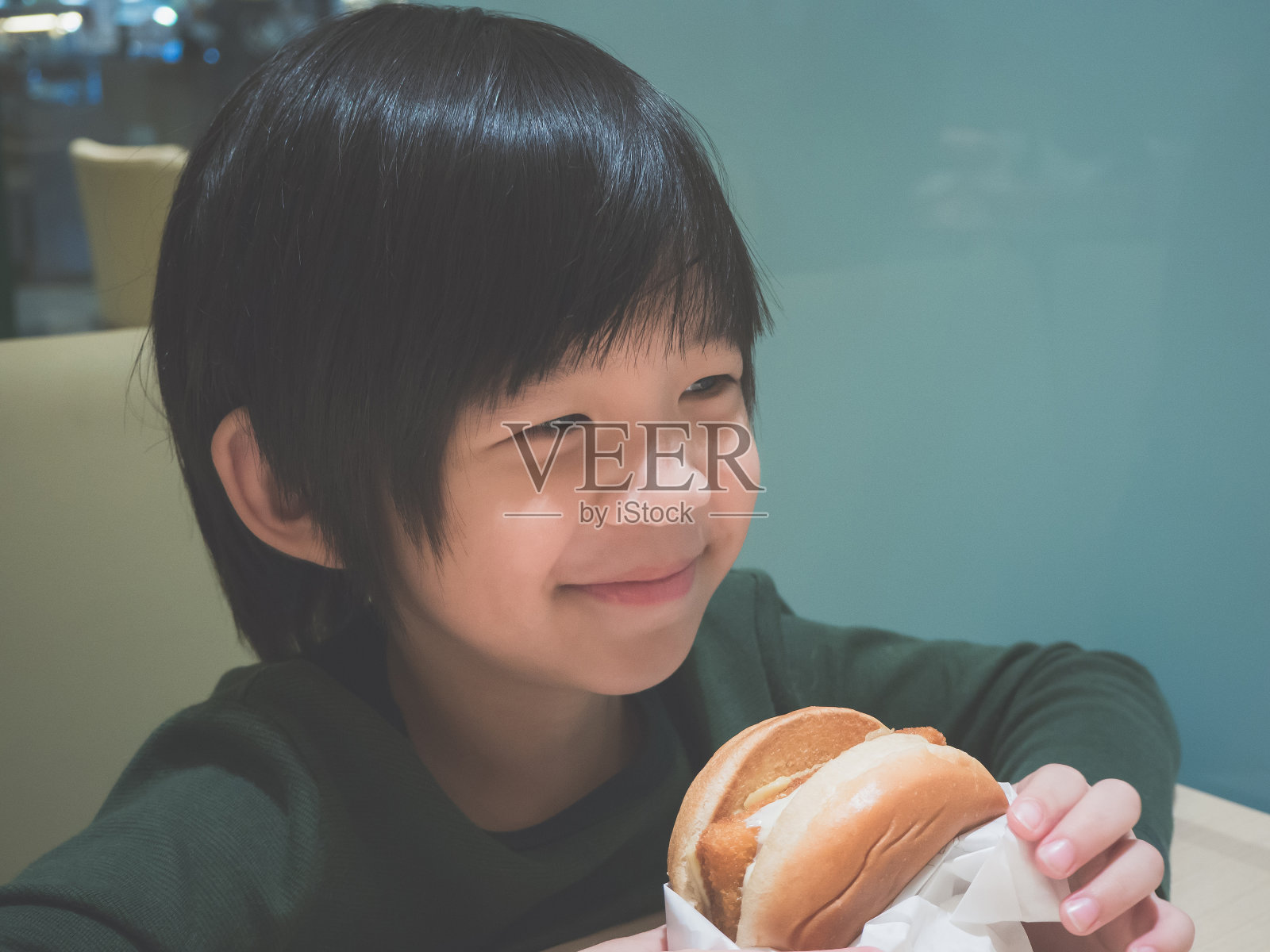亚洲女孩在餐馆吃汉堡包照片摄影图片