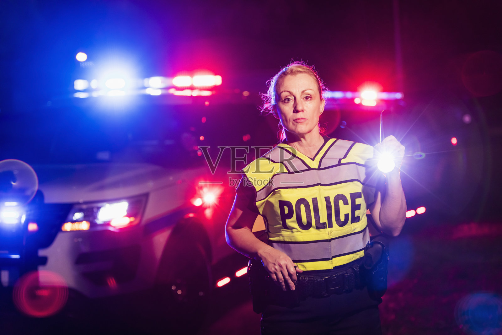 女警晚上用手电、应急灯照片摄影图片