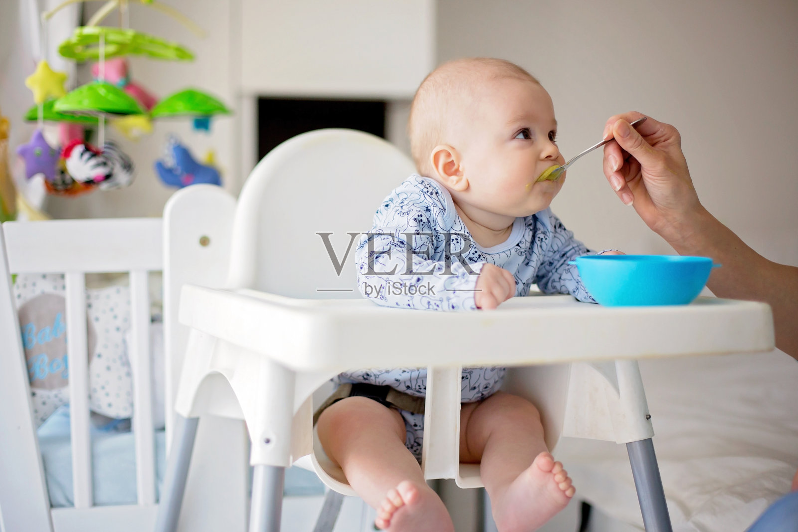 可爱的小男孩，午餐吃蔬菜泥，妈妈喂他照片摄影图片