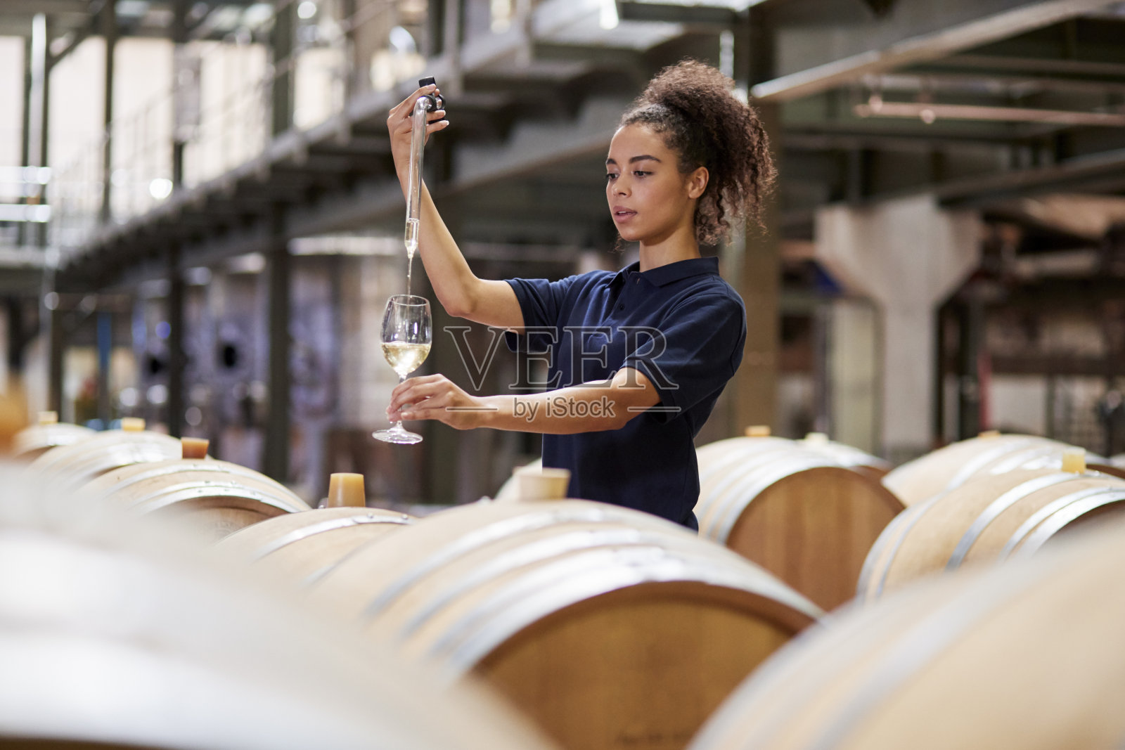 年轻女子在葡萄酒工厂的仓库里试酒照片摄影图片