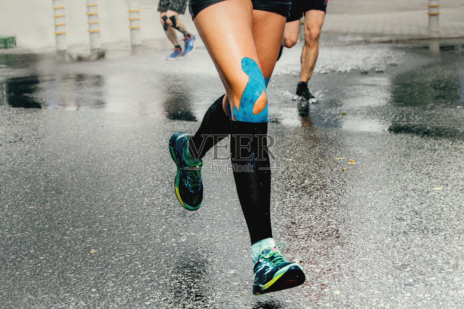 腿跑女人与肌内肌胶布和压缩袜照片摄影图片
