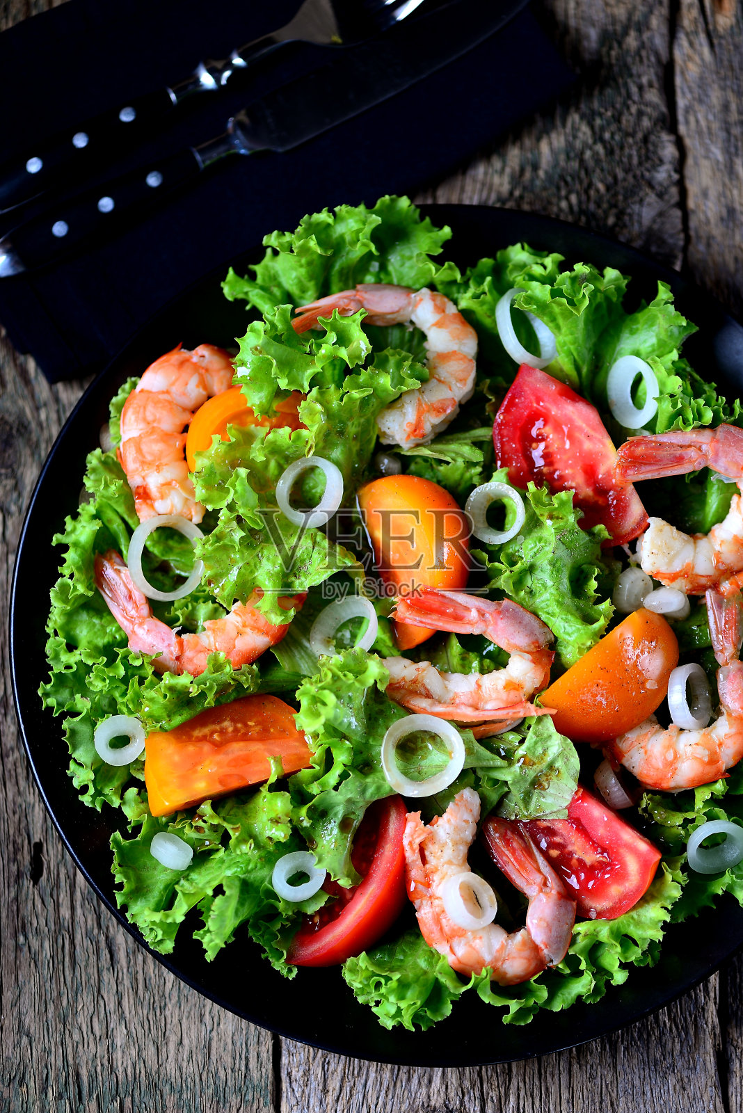 健康的沙拉，红色和黄色的西红柿，虾，甜洋葱，生菜，香醋和橄榄油。照片摄影图片