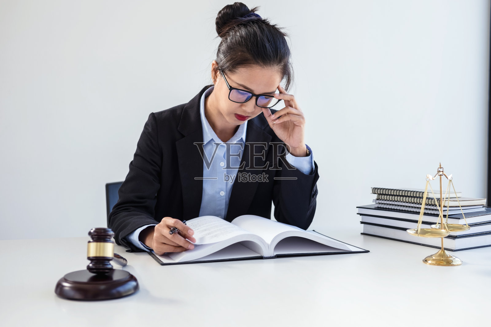 法律、咨询和司法概念，职业女性律师在法庭上工作，坐在桌子旁，用小木槌和正义的天平签署文件照片摄影图片
