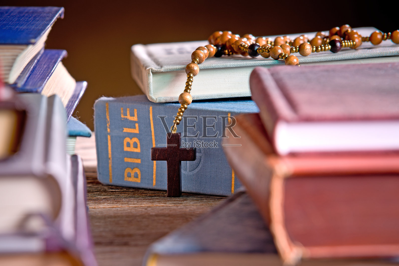 书架上的圣经和木制念珠照片摄影图片