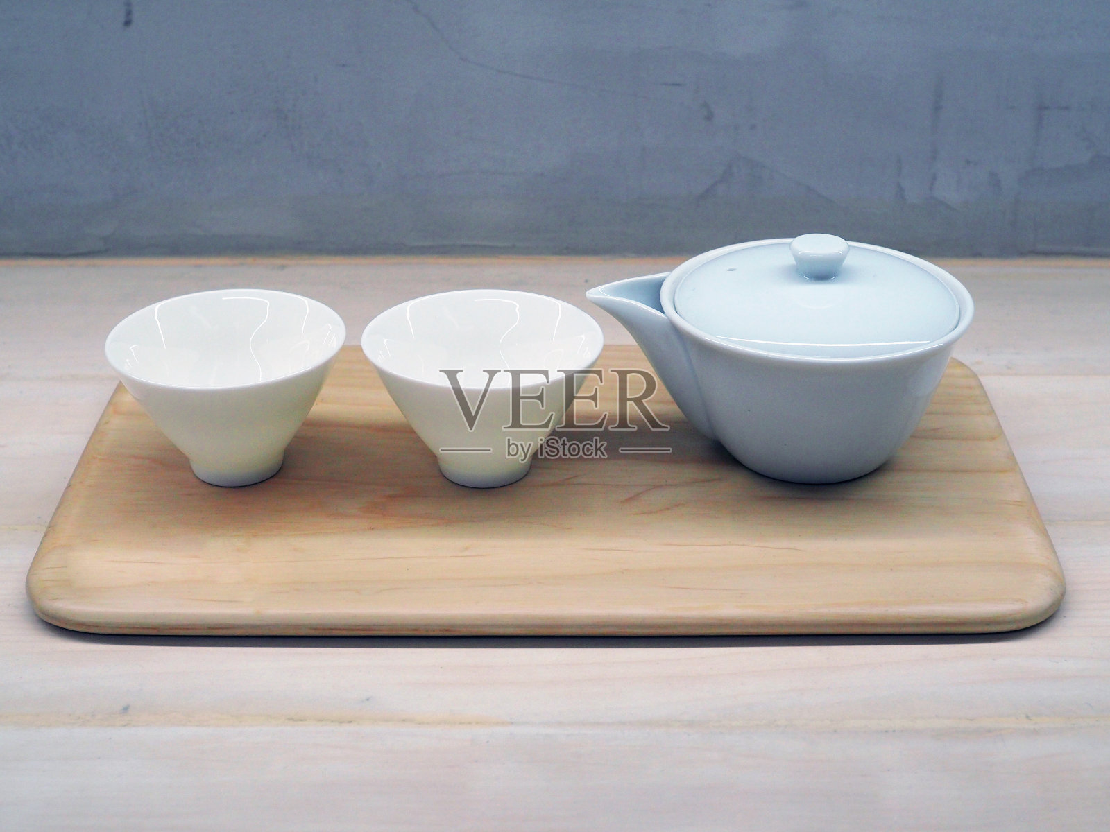 日式陶瓷茶壶、茶杯、木托盘放在桌上;传统、文化、生活方式。照片摄影图片
